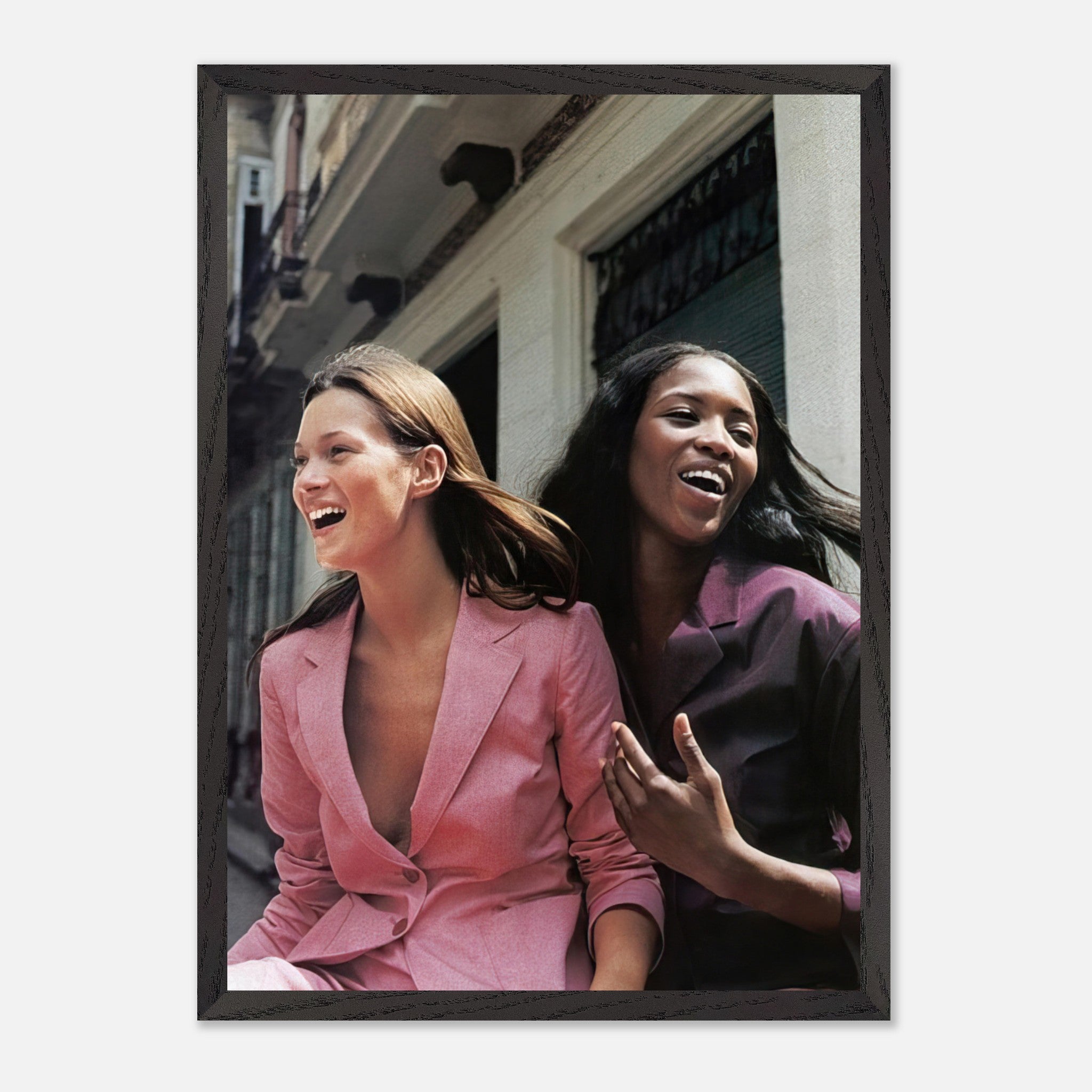 Naomi Campbell and Kate Moss laughing in stylish outfits, embodying fashion's golden era in a museum-quality print.