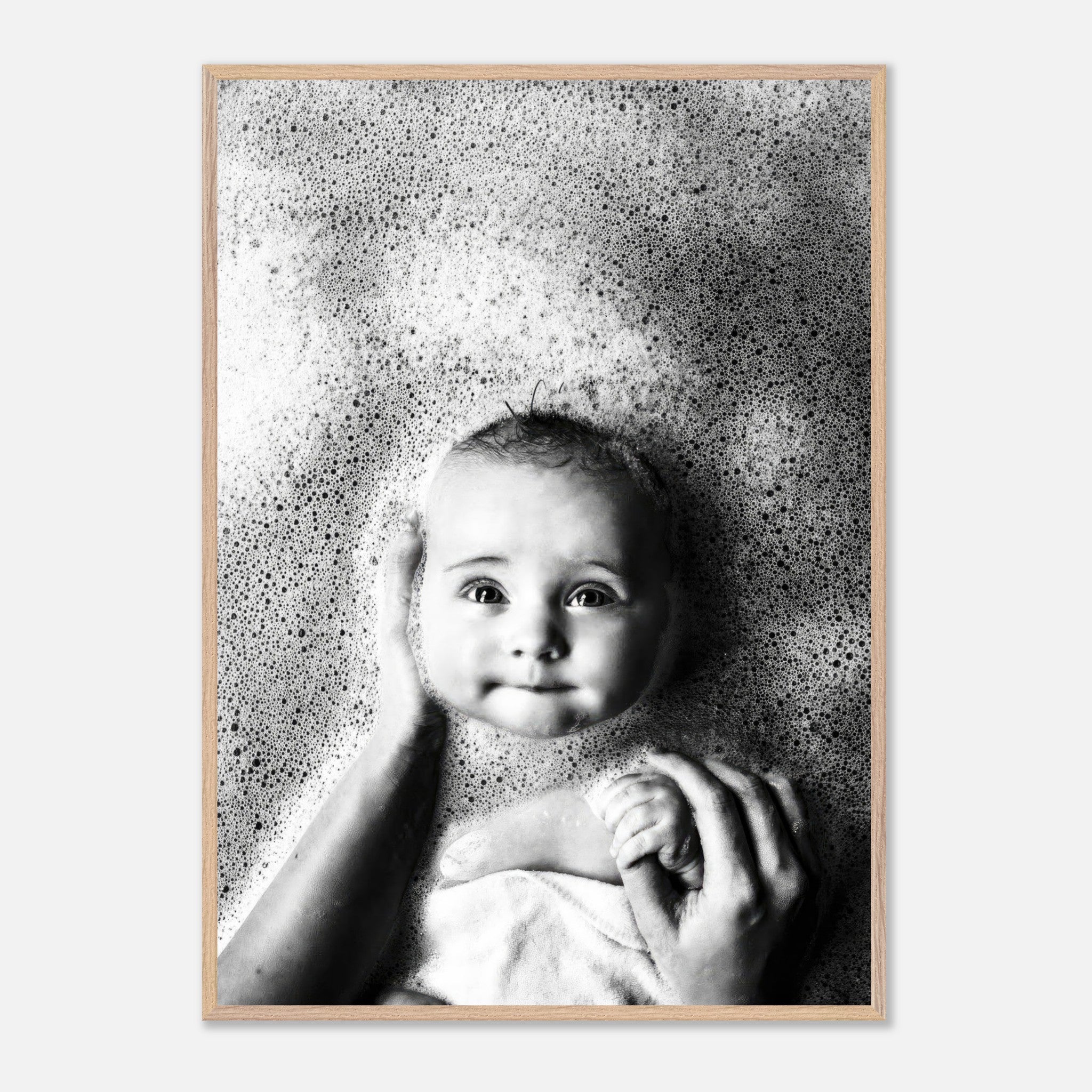 Black-and-white photo of a smiling baby in a bubble bath, showcasing innocence and joy in childhood.