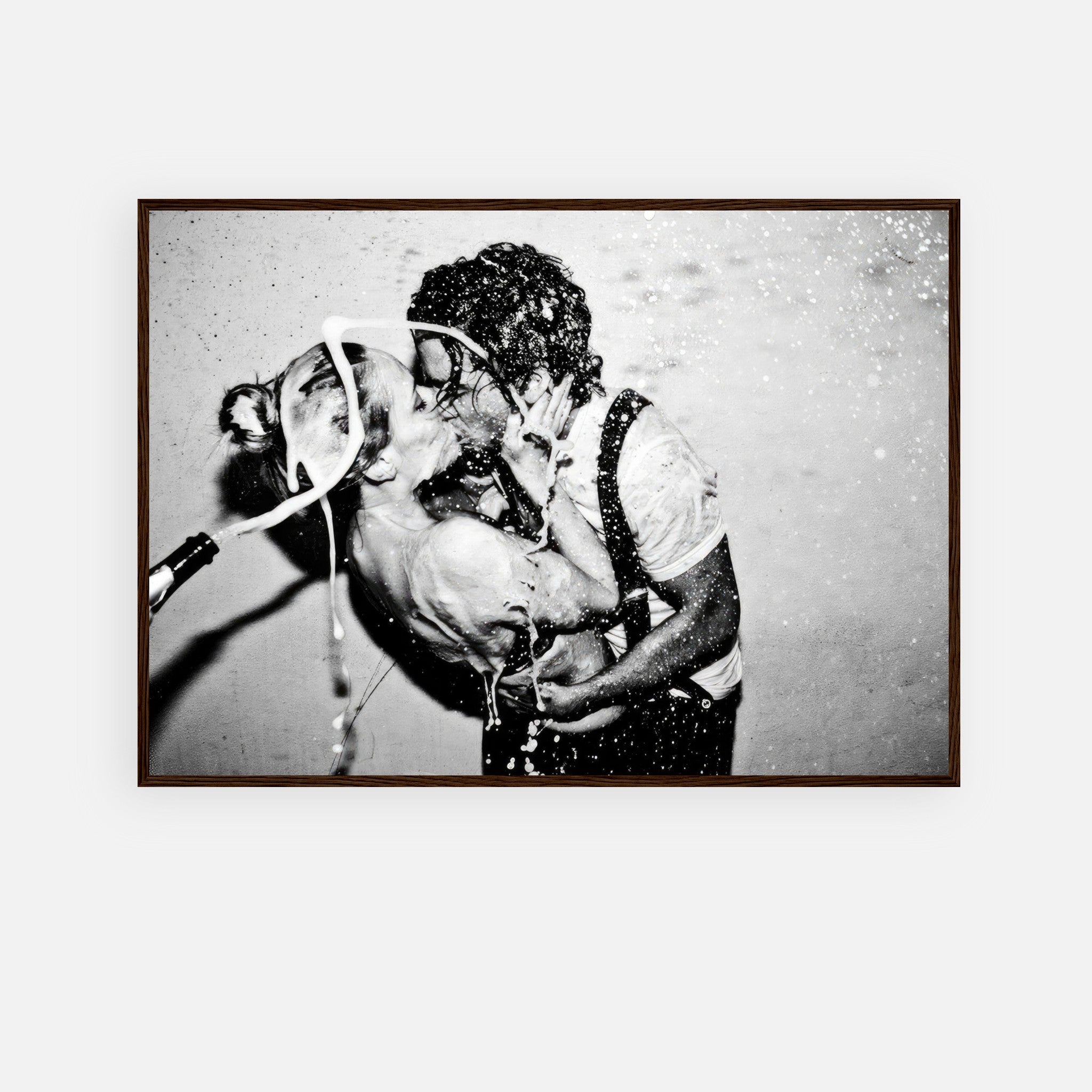 Framed print of Johnny Depp and Kate Moss sharing a passionate kiss with champagne splashing in black-and-white.