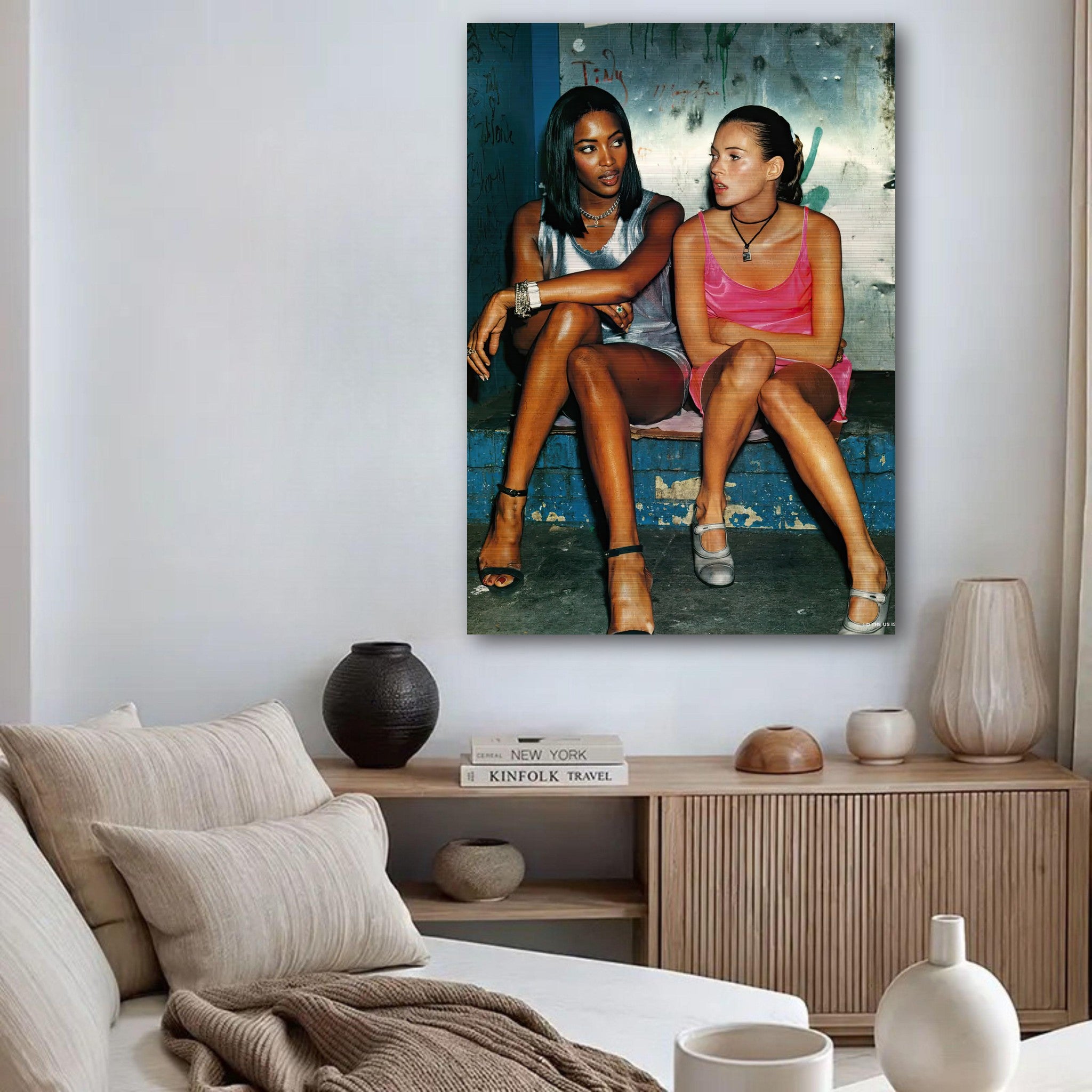 Naomi Campbell and Kate Moss stylishly seated, showcasing 90s fashion in a brushed metal artwork.