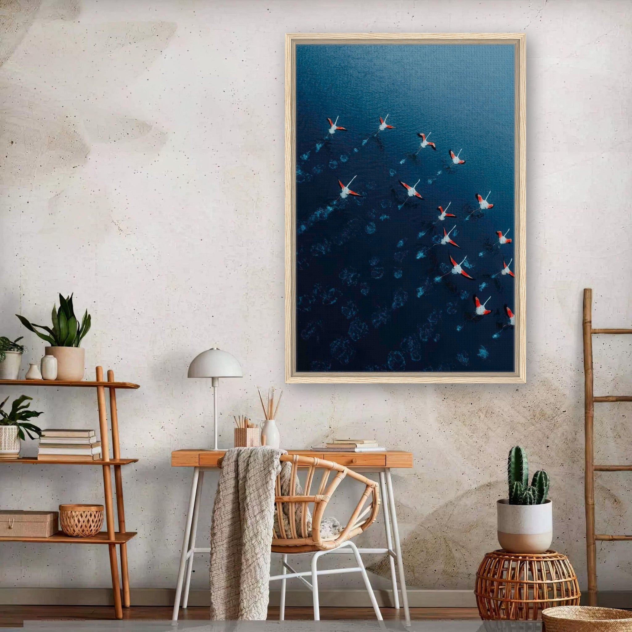 Framed canvas print of flamingos in flight over blue water, showcasing aerial drone photography in a stylish room.