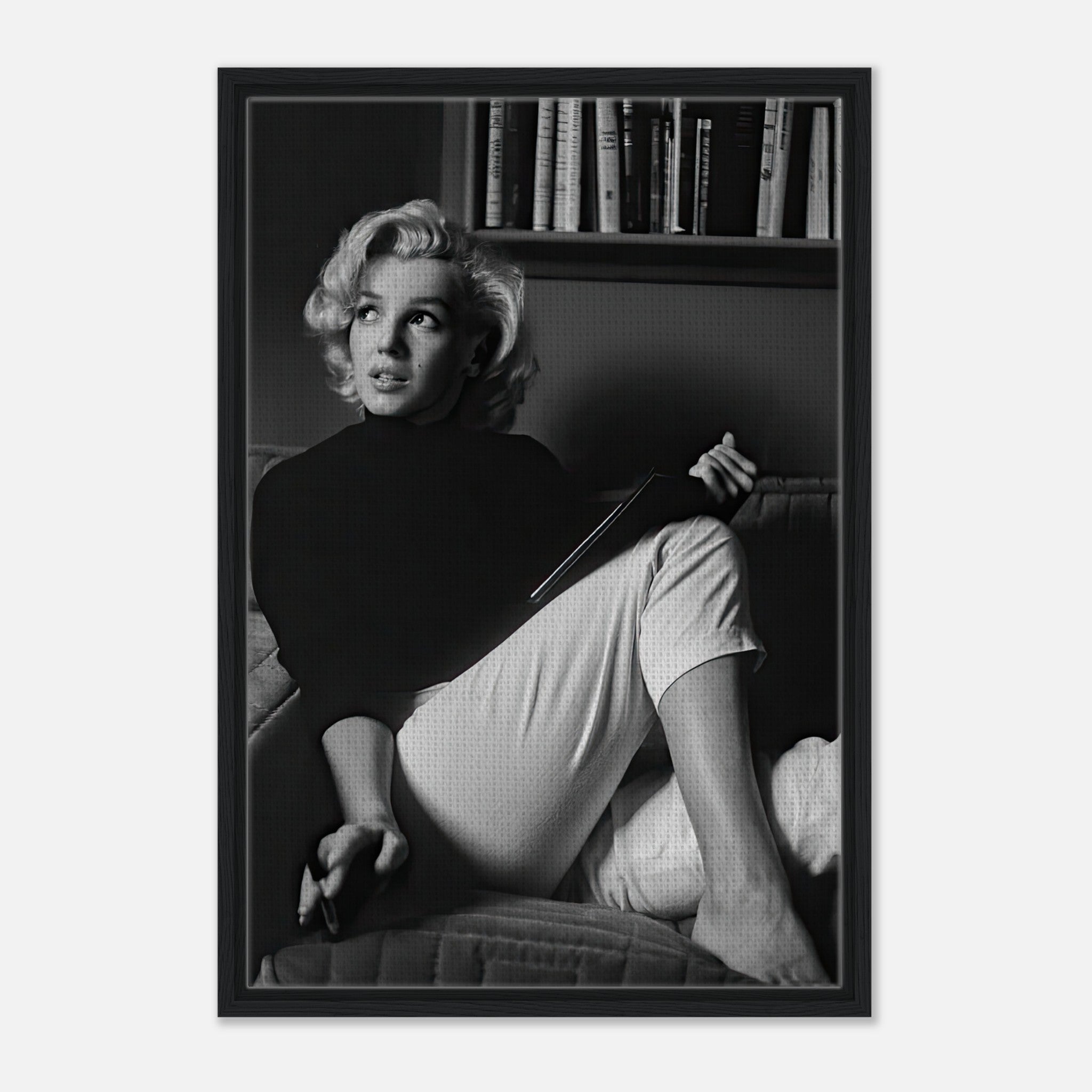 Marilyn Monroe reading a book in a black-and-white framed canvas print, showcasing elegance and introspection.