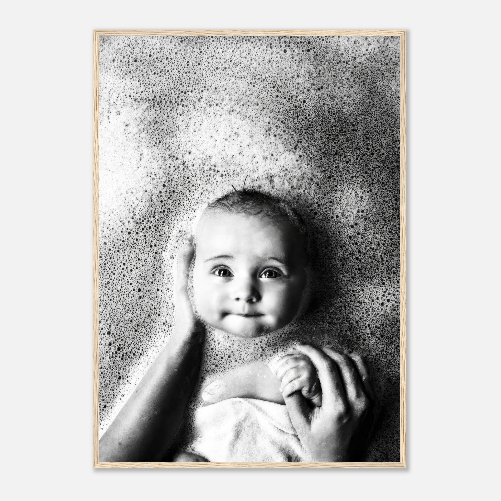 Black-and-white framed print of a smiling baby surrounded by bubbles during bath time.