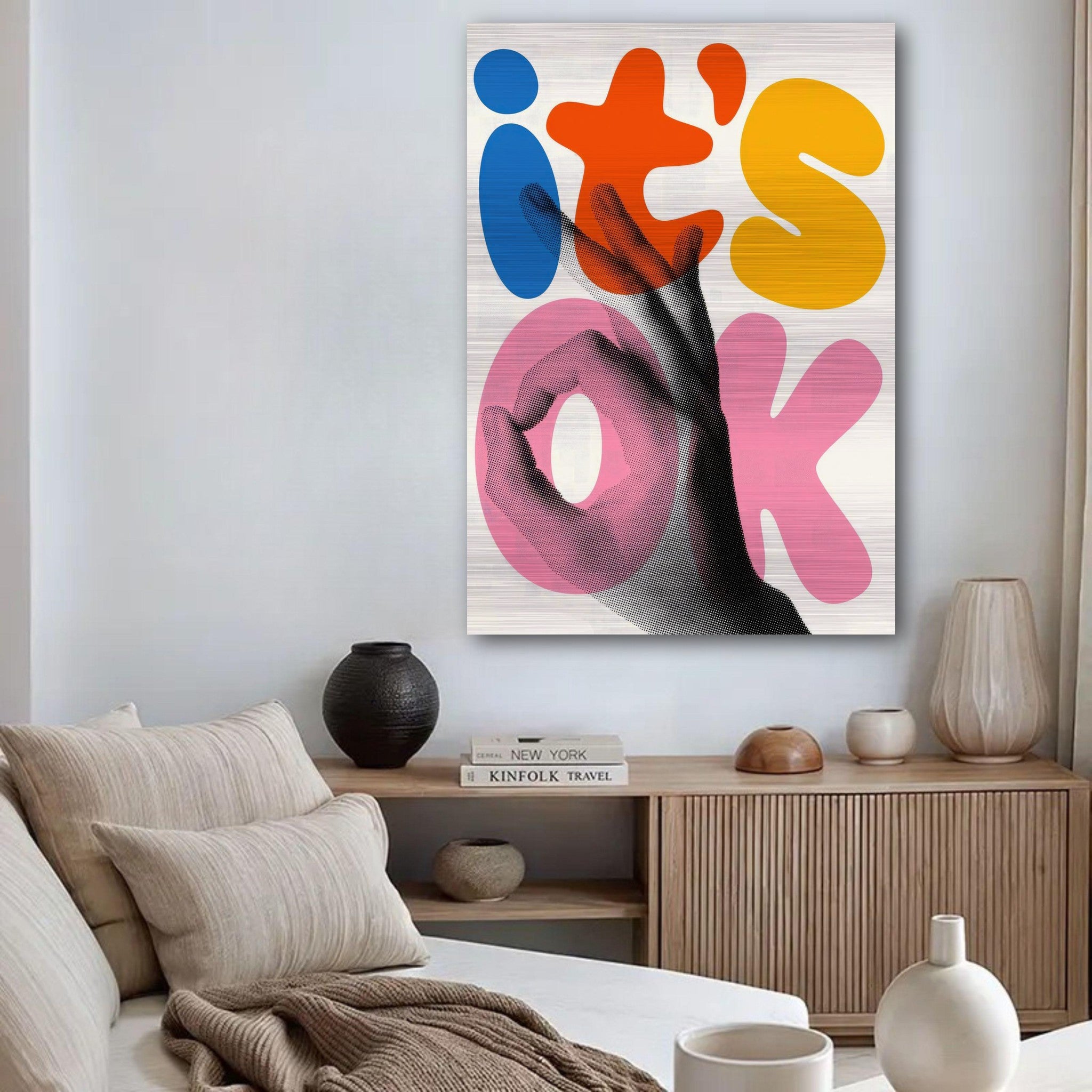 Retro abstract pop art print with oversized 'it's OK' text and hand gesture in vibrant colors, displayed in a modern living room.