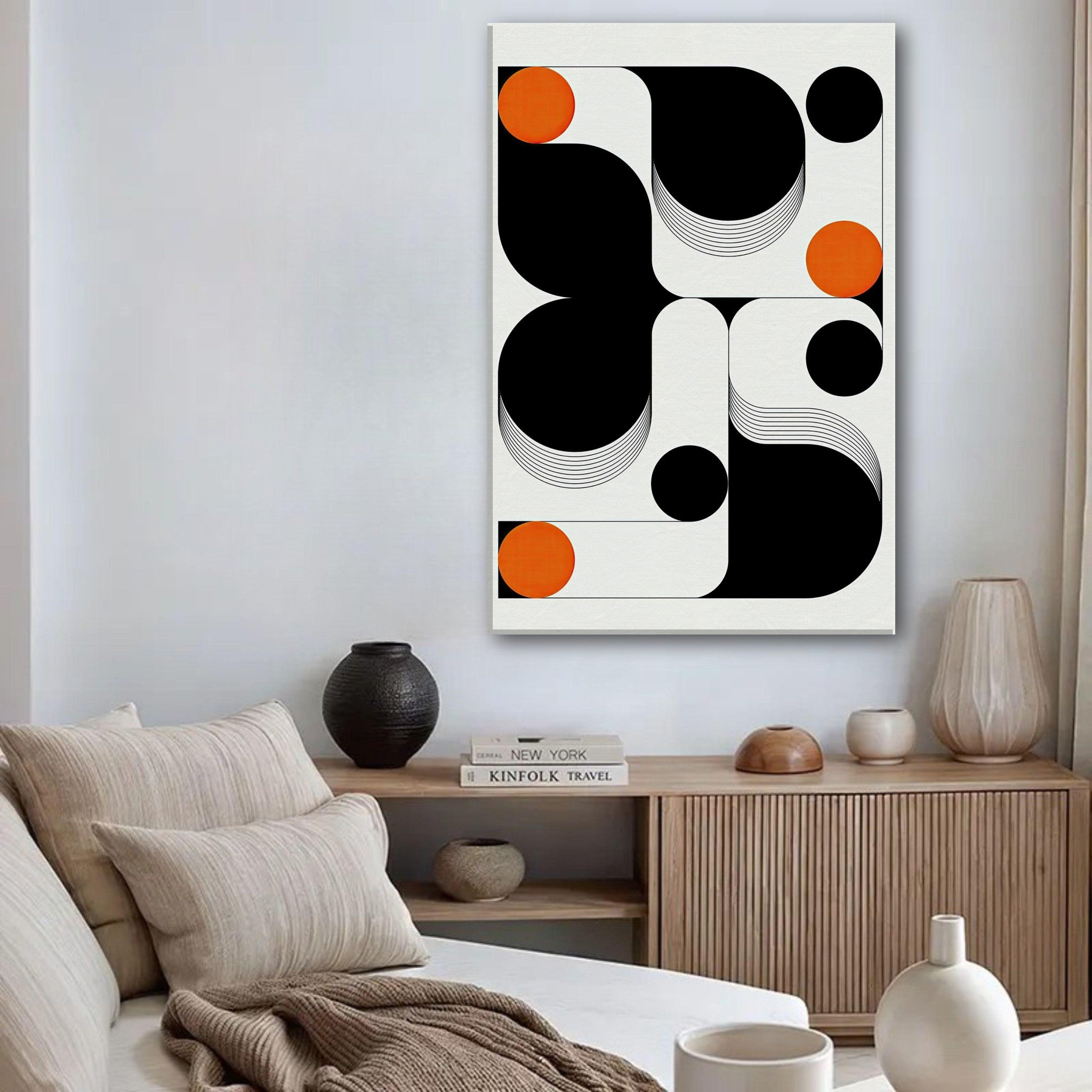 Modern geometric abstract art canvas print featuring black, white, and vibrant orange shapes in a contemporary living room.