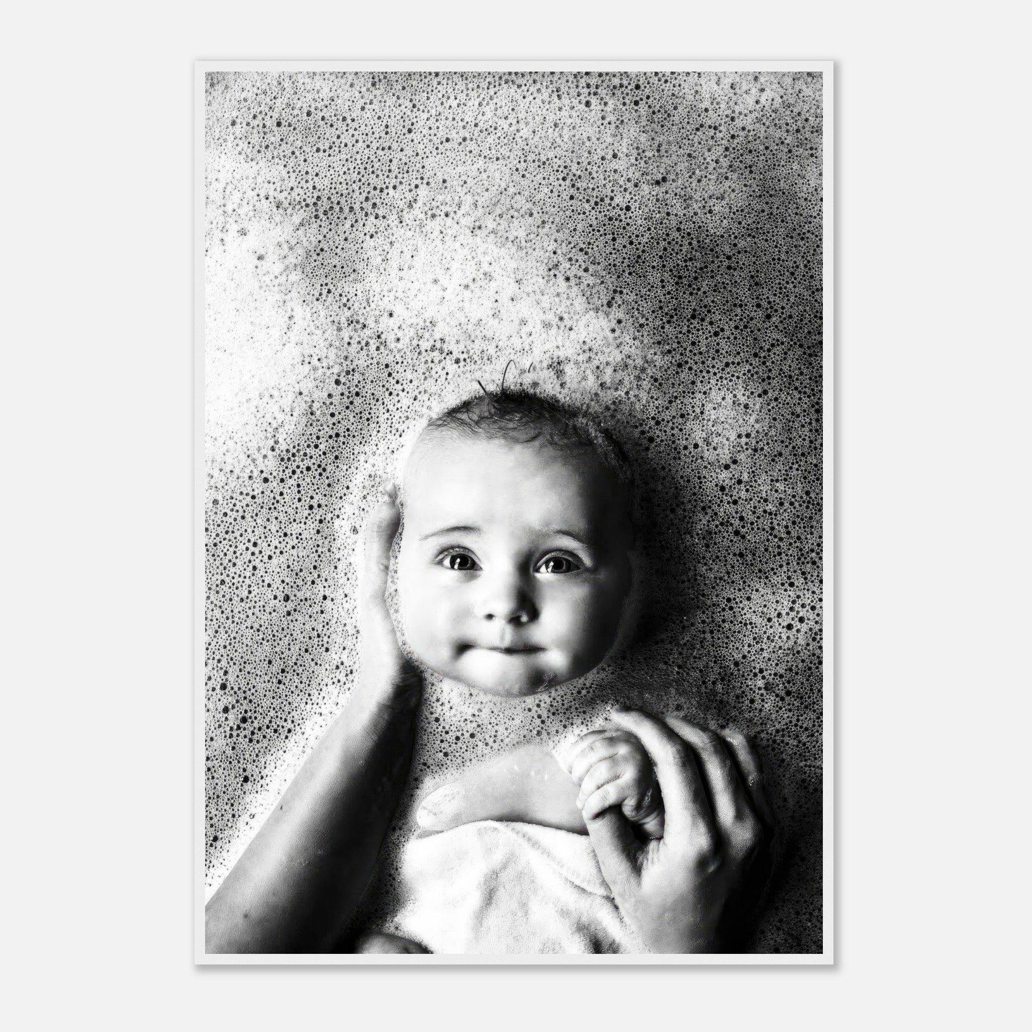 Black-and-white framed print of a baby in bubbles, capturing the innocence and joy of bath time.