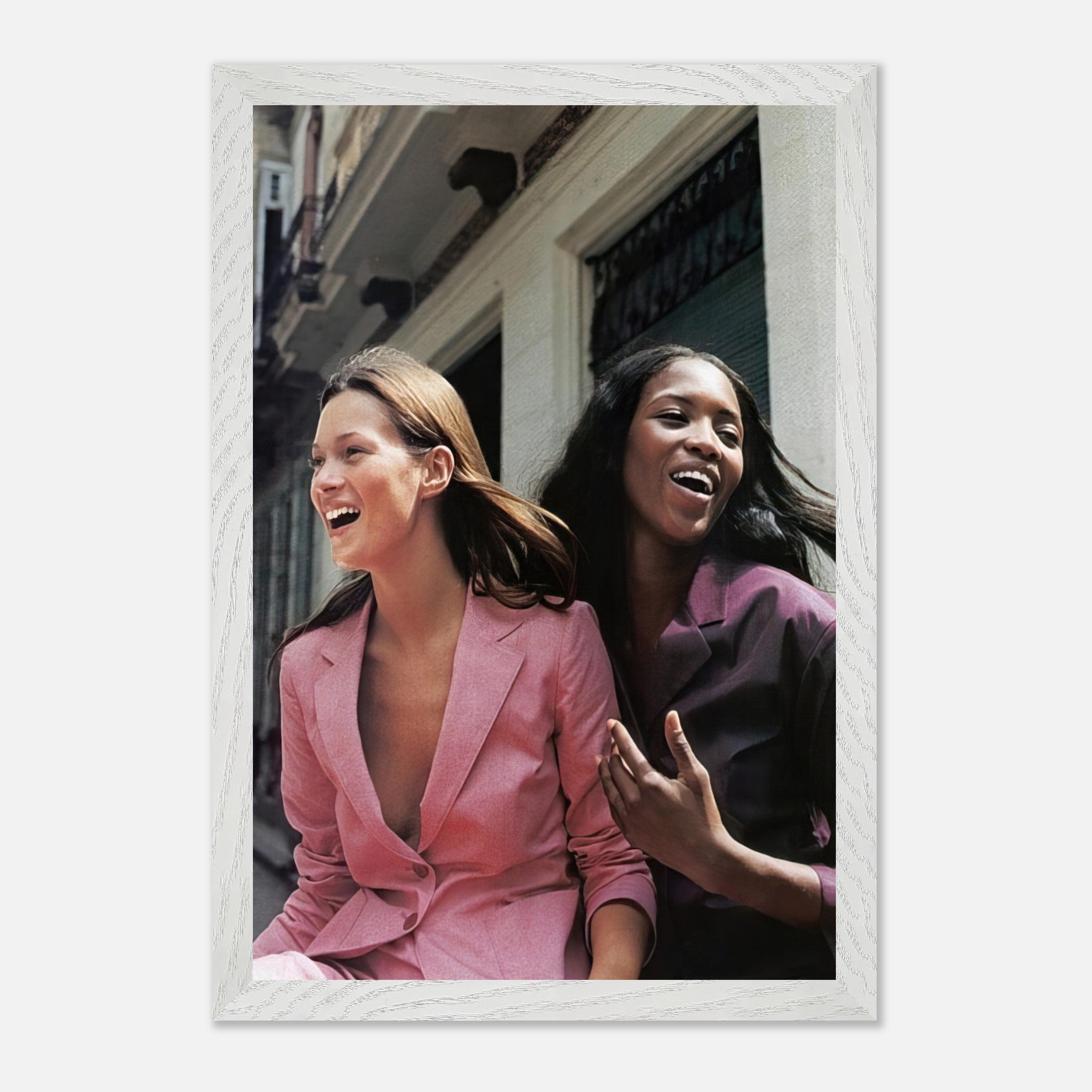 Naomi Campbell and Kate Moss laughing in stylish pink and purple suits, capturing high fashion friendship in a museum-quality fine art print.