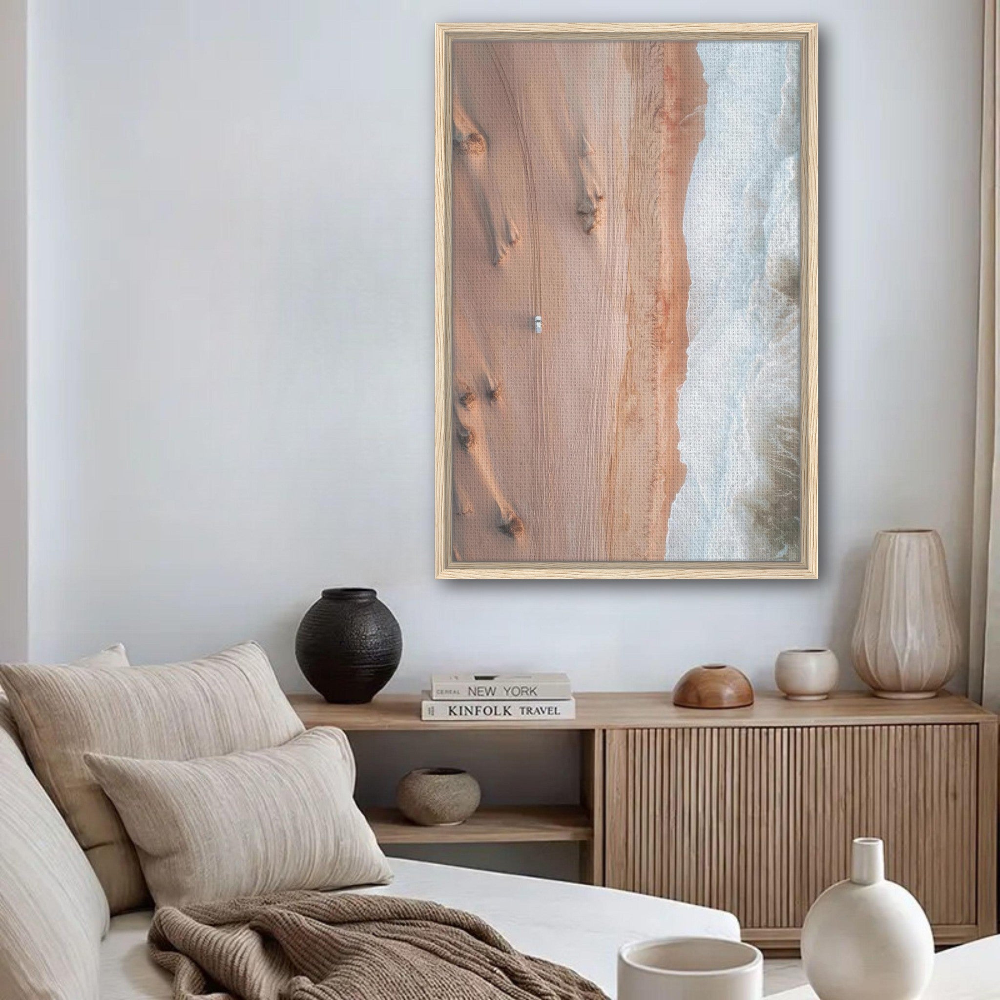 Framed canvas print of desert and ocean meeting, showcasing drone photography in a modern living room setting.