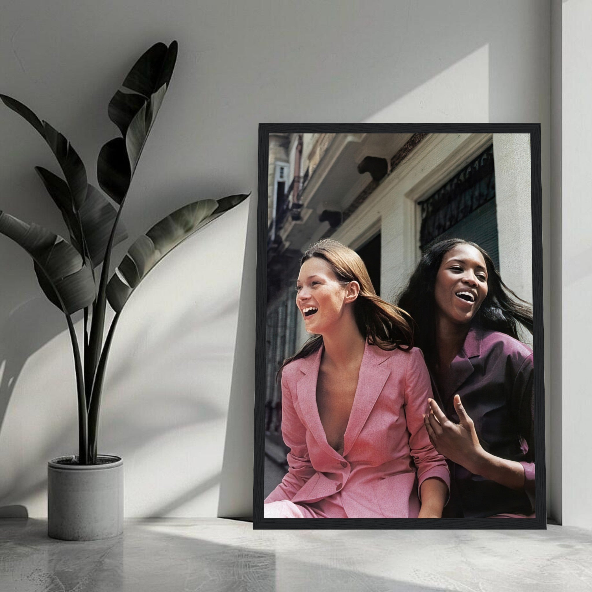 Naomi Campbell and Kate Moss laughing in a stylish framed print, showcasing iconic fashion moments.