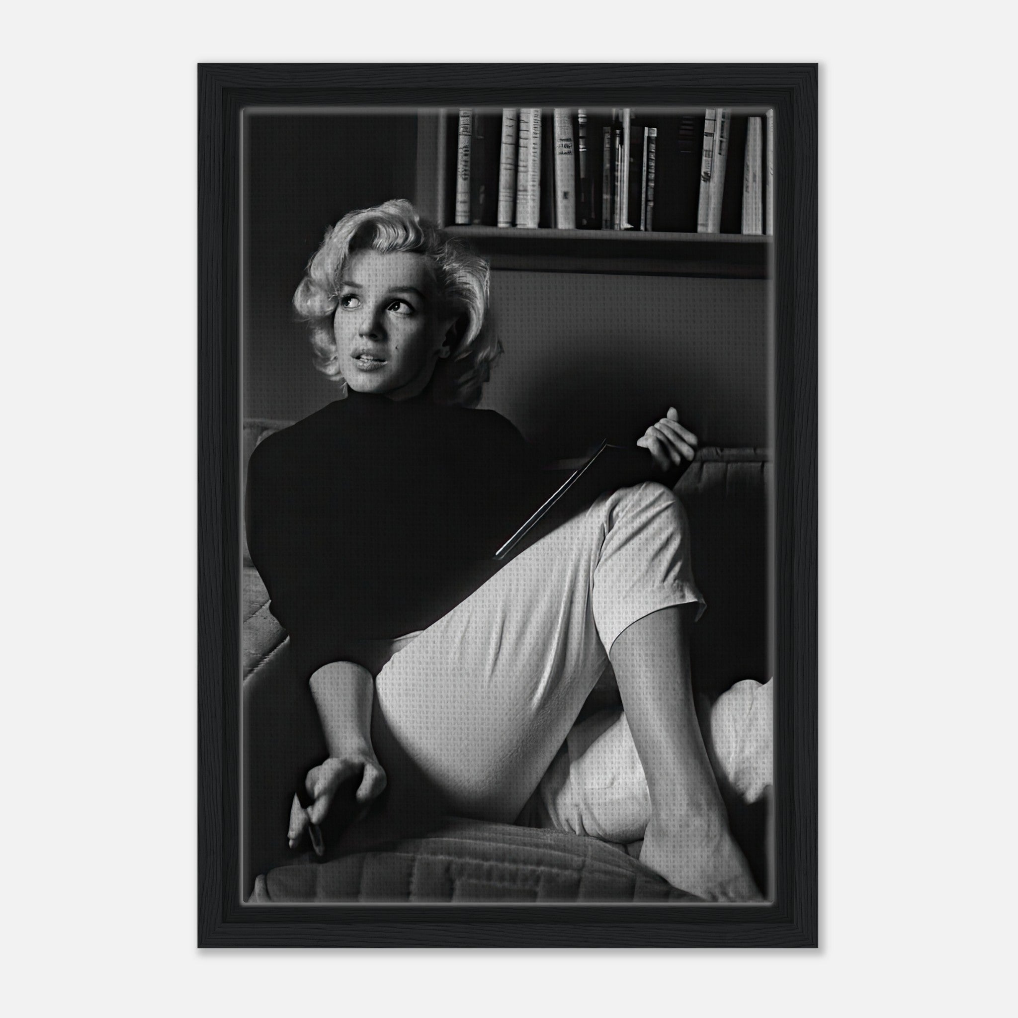 Marilyn Monroe reading a book in a black-and-white framed canvas print, showcasing elegance and sophistication.