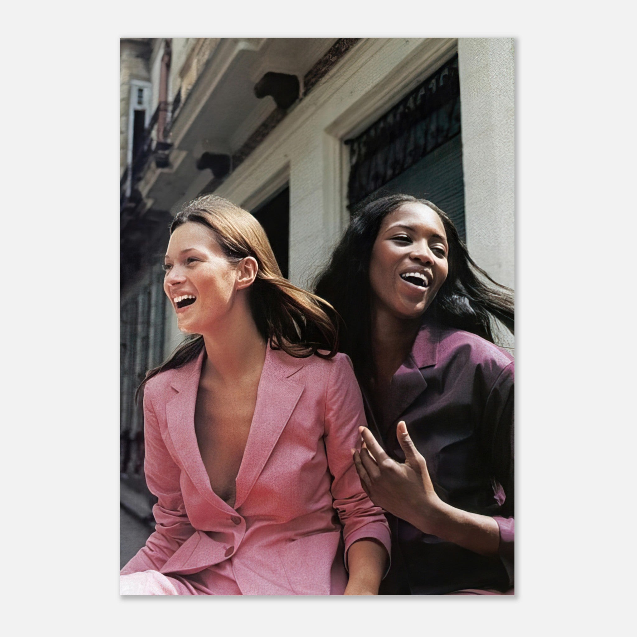 Naomi Campbell and Kate Moss smiling in stylish outfits, capturing timeless beauty and elegance in fashion.