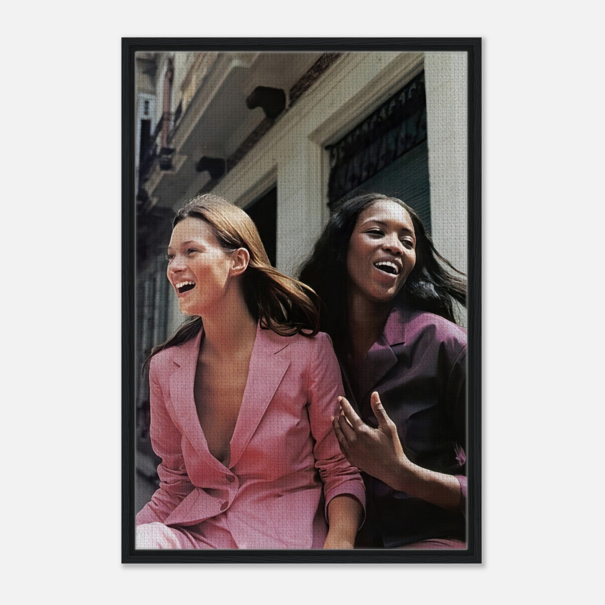Naomi Campbell and Kate Moss in pink suits smiling together, framed canvas print celebrating fashion icons.
