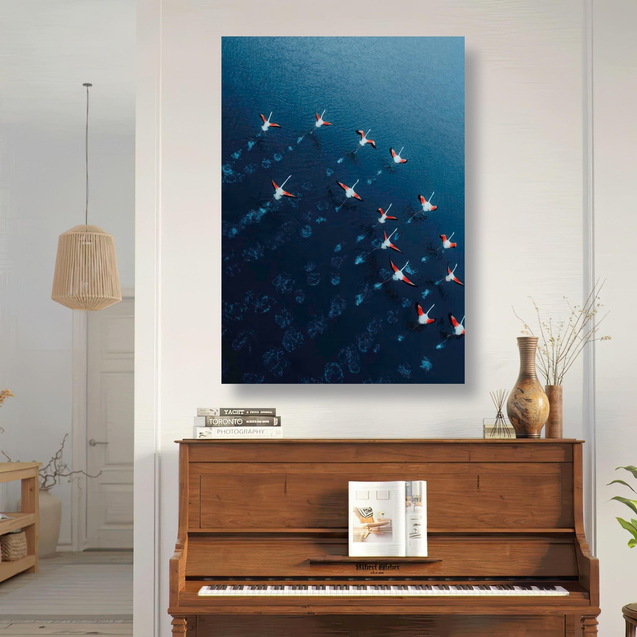 Aerial view of flamingos over blue waters, showcased in a stylish home setting with a piano.