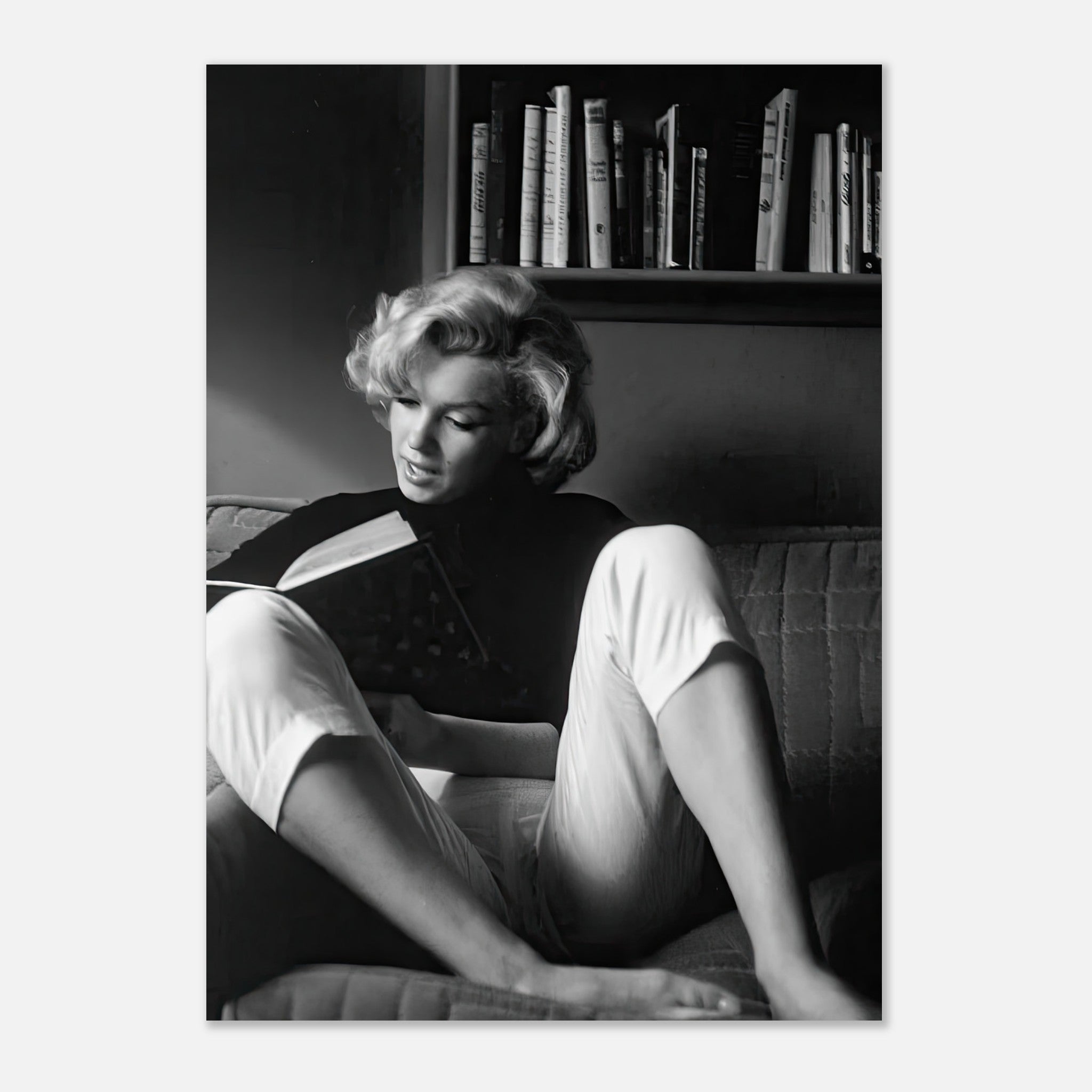 Marilyn Monroe reading a book at home in a black-and-white poster, capturing vintage Hollywood charm.