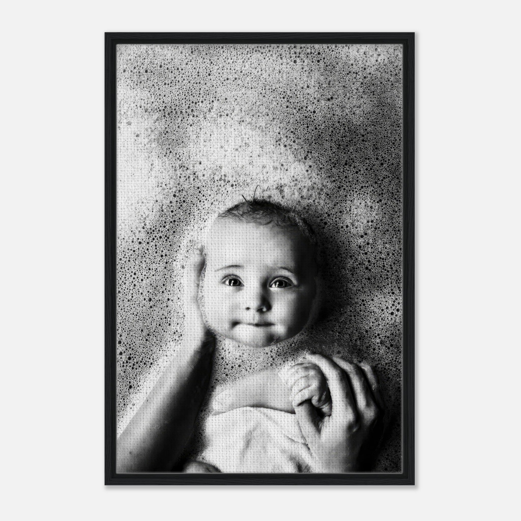 Framed black-and-white canvas print of a baby enjoying bath time surrounded by gentle bubbles.