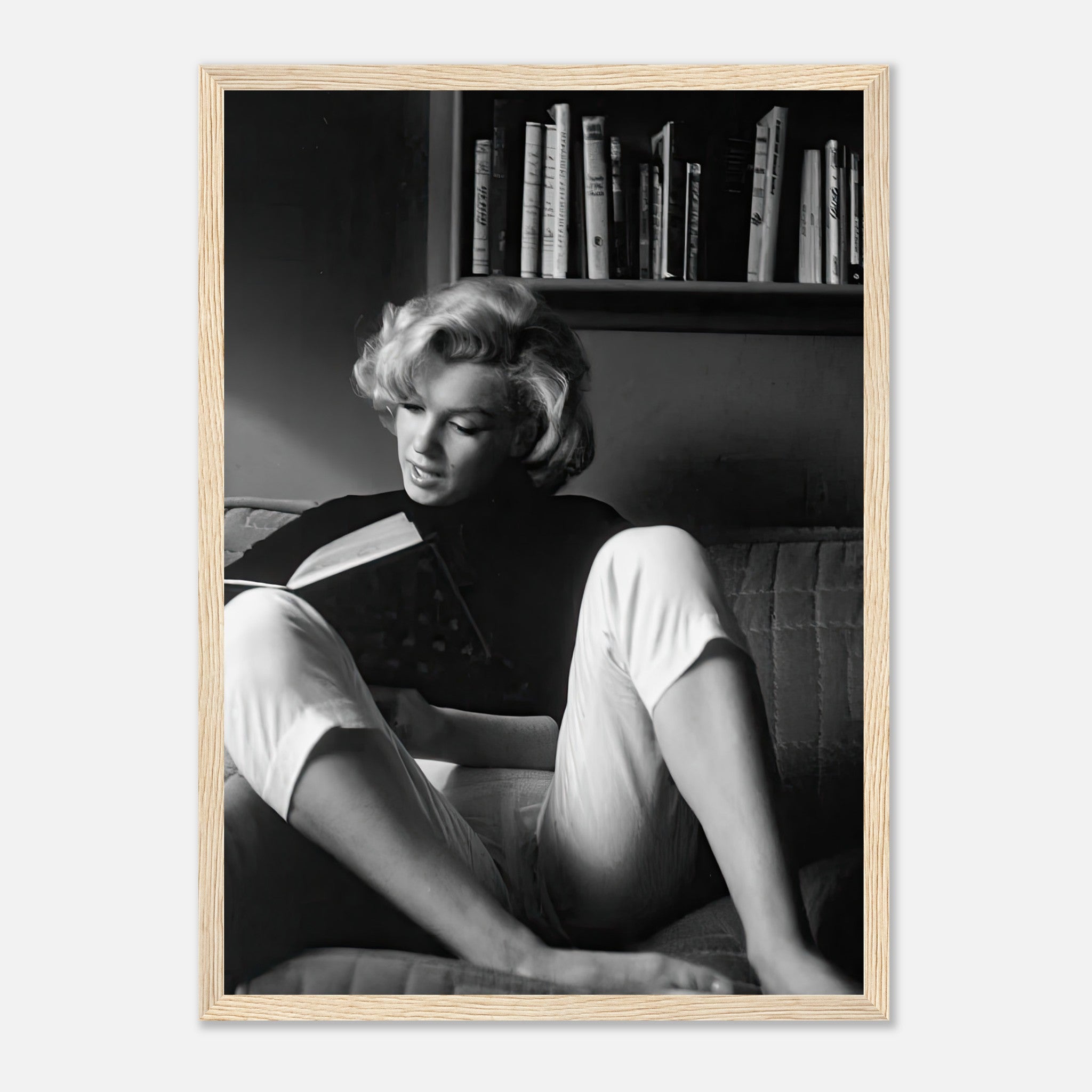 Marilyn Monroe reading a book at home, framed print capturing classic Hollywood sophistication.