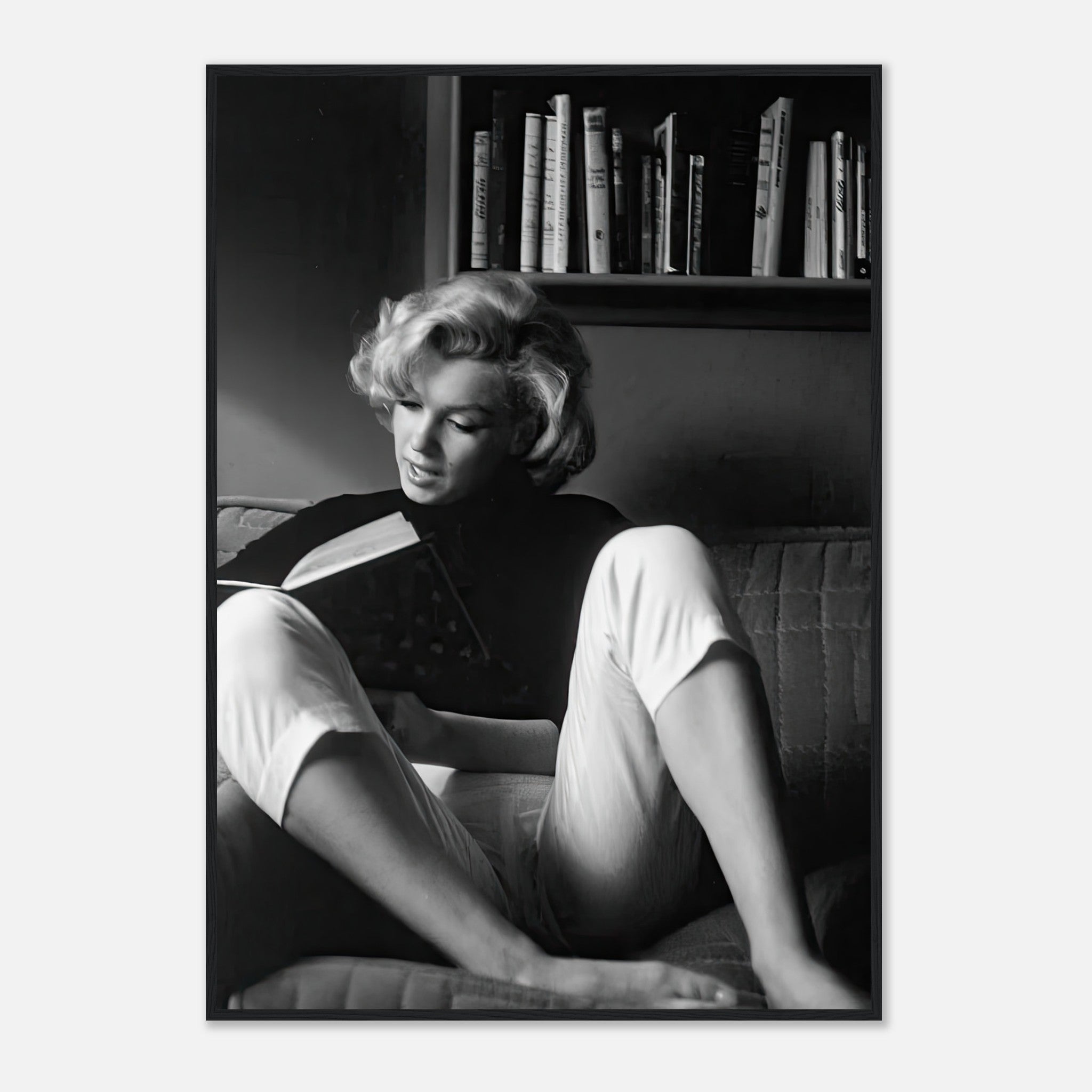 Marilyn Monroe reading at home in a black-and-white framed print, showcasing classic Hollywood glamour and sophistication.