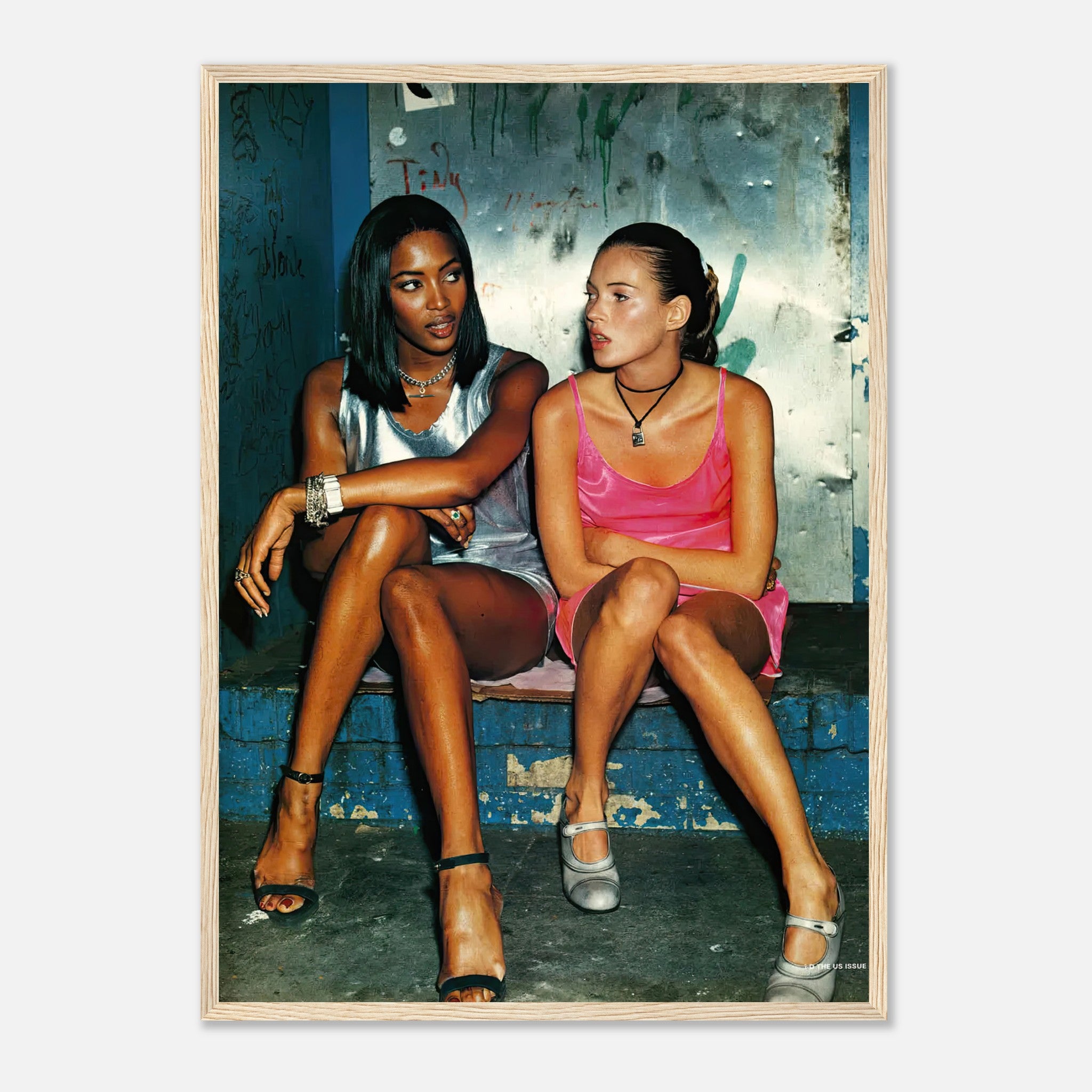 Naomi Campbell and Kate Moss stylishly posed in a framed print, capturing 90s fashion and supermodel charisma.