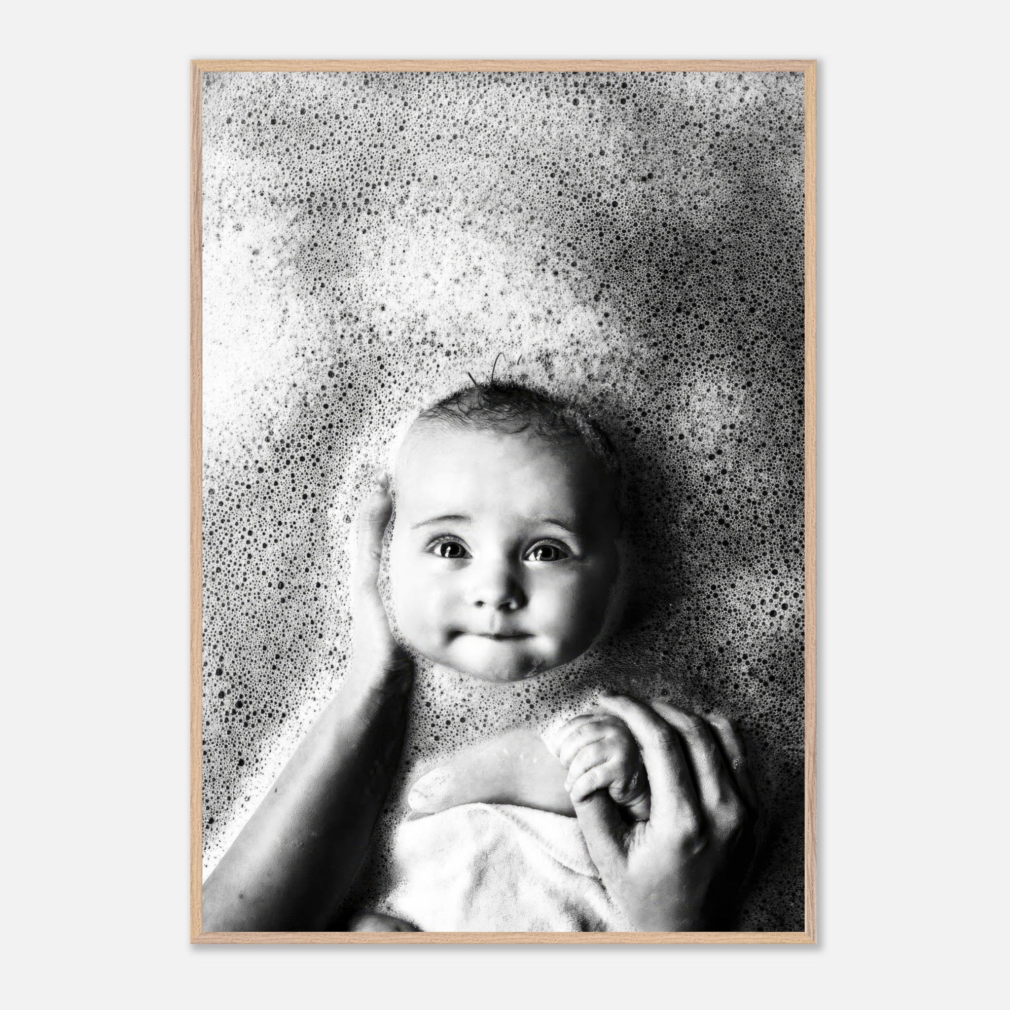 Black-and-white fine art print of a baby enjoying bath time with bubbles, capturing innocence and joy.