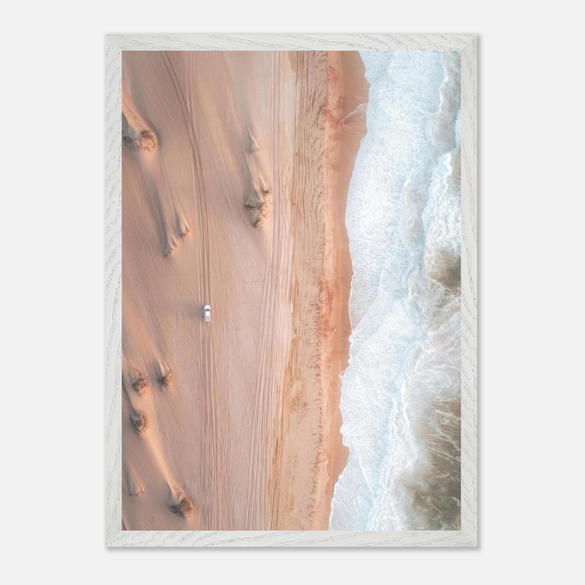 Drone photography of desert meeting ocean, highlighting stunning contrast of sand dunes and waves.