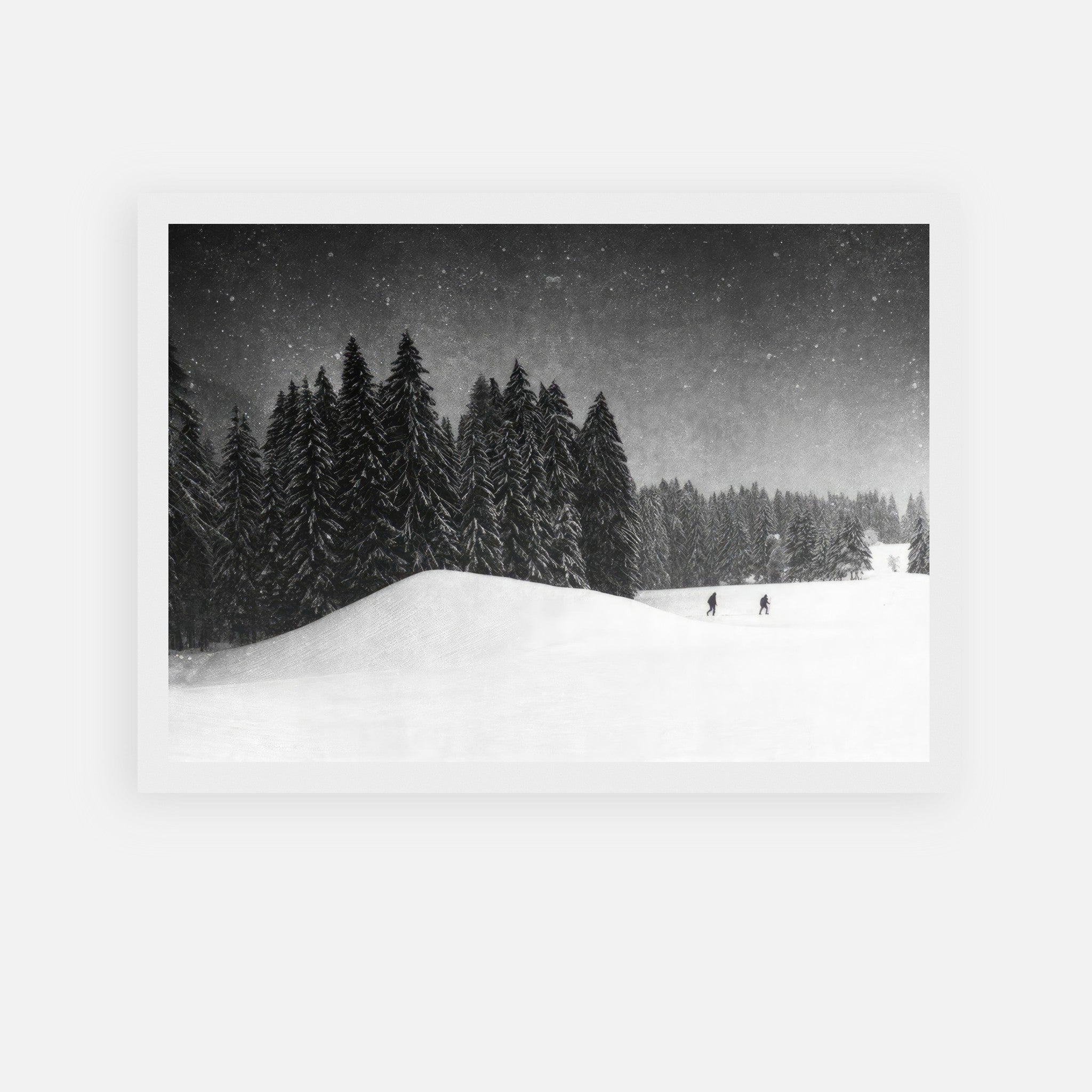 Black-and-white framed print of a serene winter landscape with snow-covered evergreens and skiers.