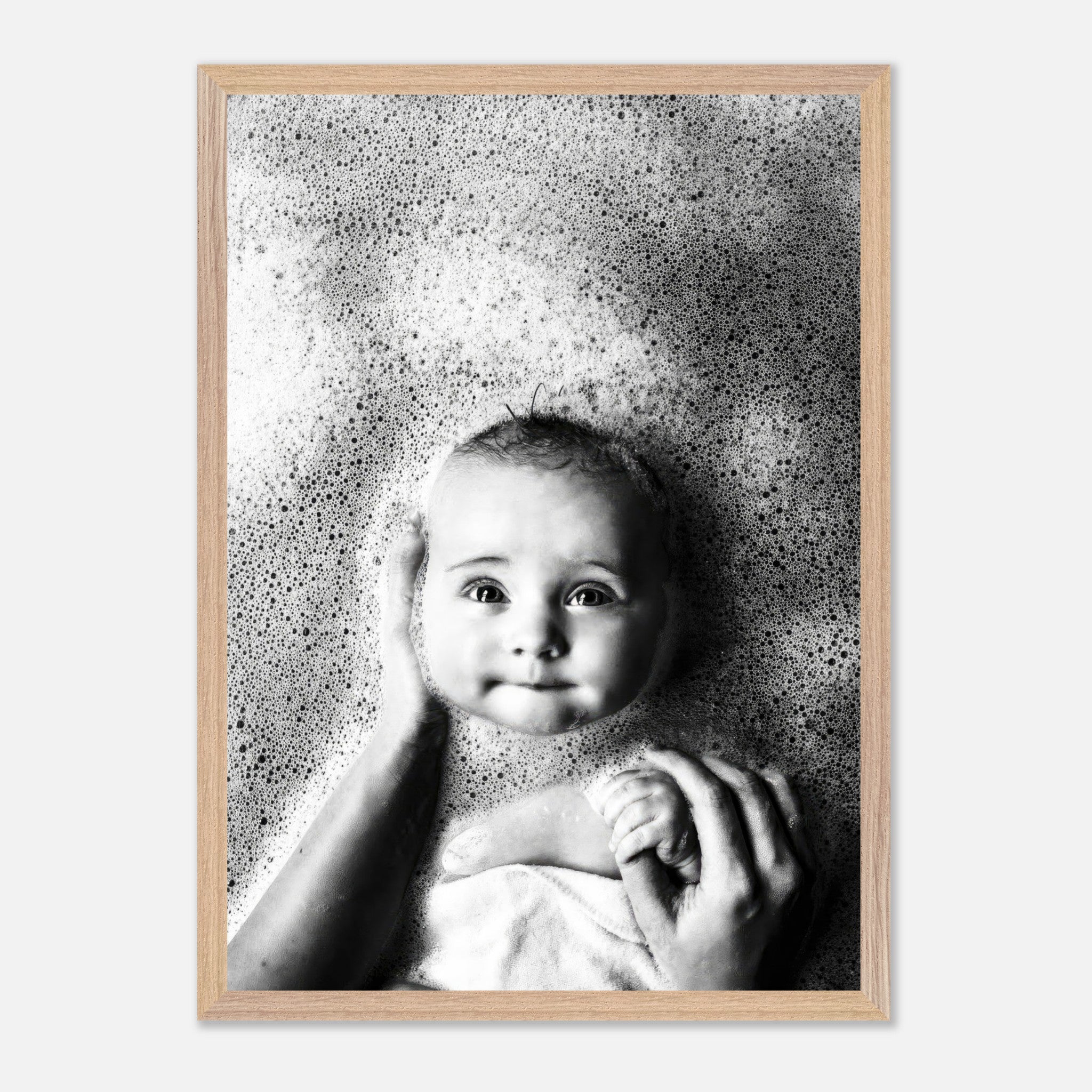 Black-and-white fine art print of a smiling baby surrounded by bubbles during bath time.