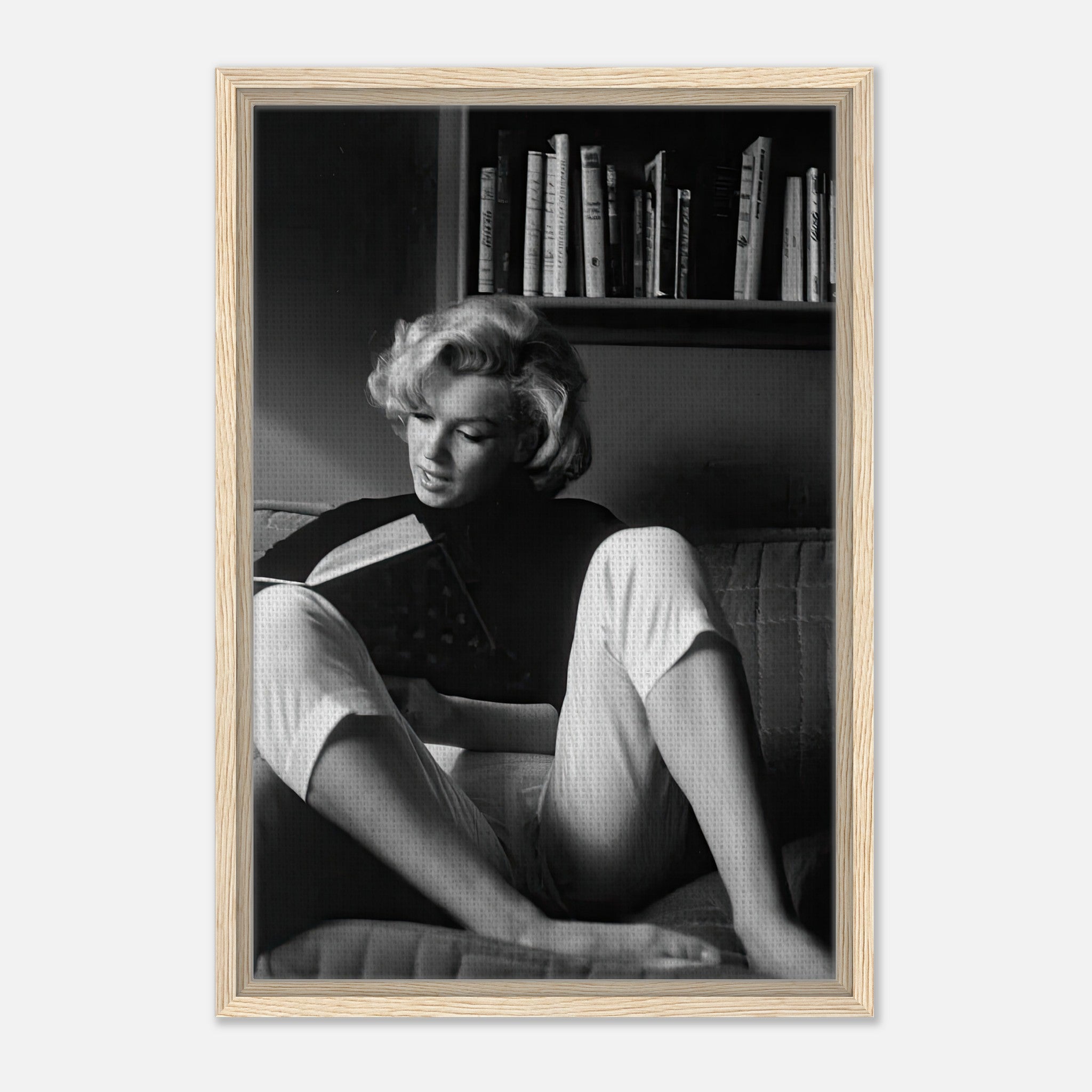 Marilyn Monroe reading a book at home in a black-and-white framed canvas print, showcasing elegance and vintage charm.