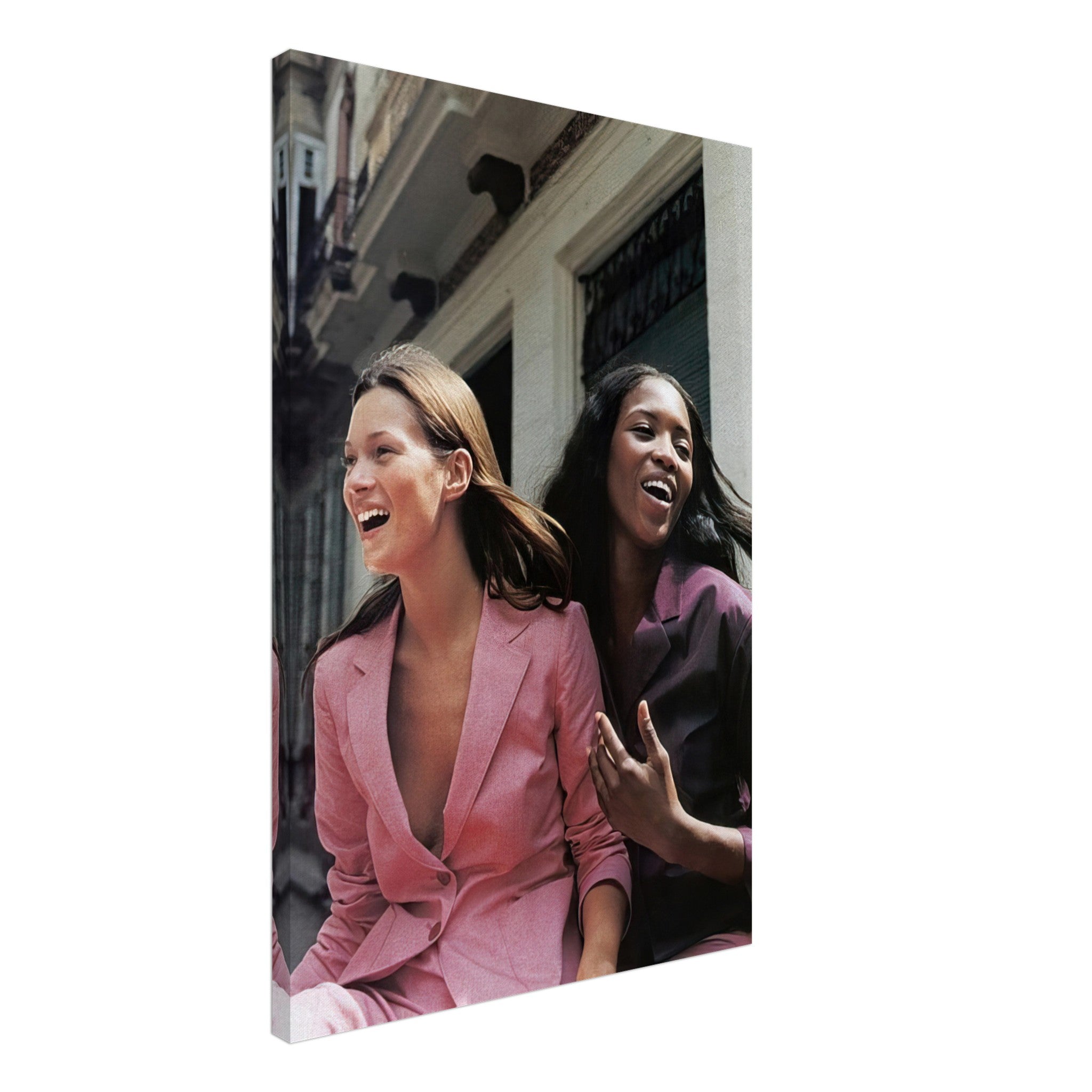 Naomi Campbell and Kate Moss laughing together in elegant fashion suits on a canvas print, capturing a moment of joy.