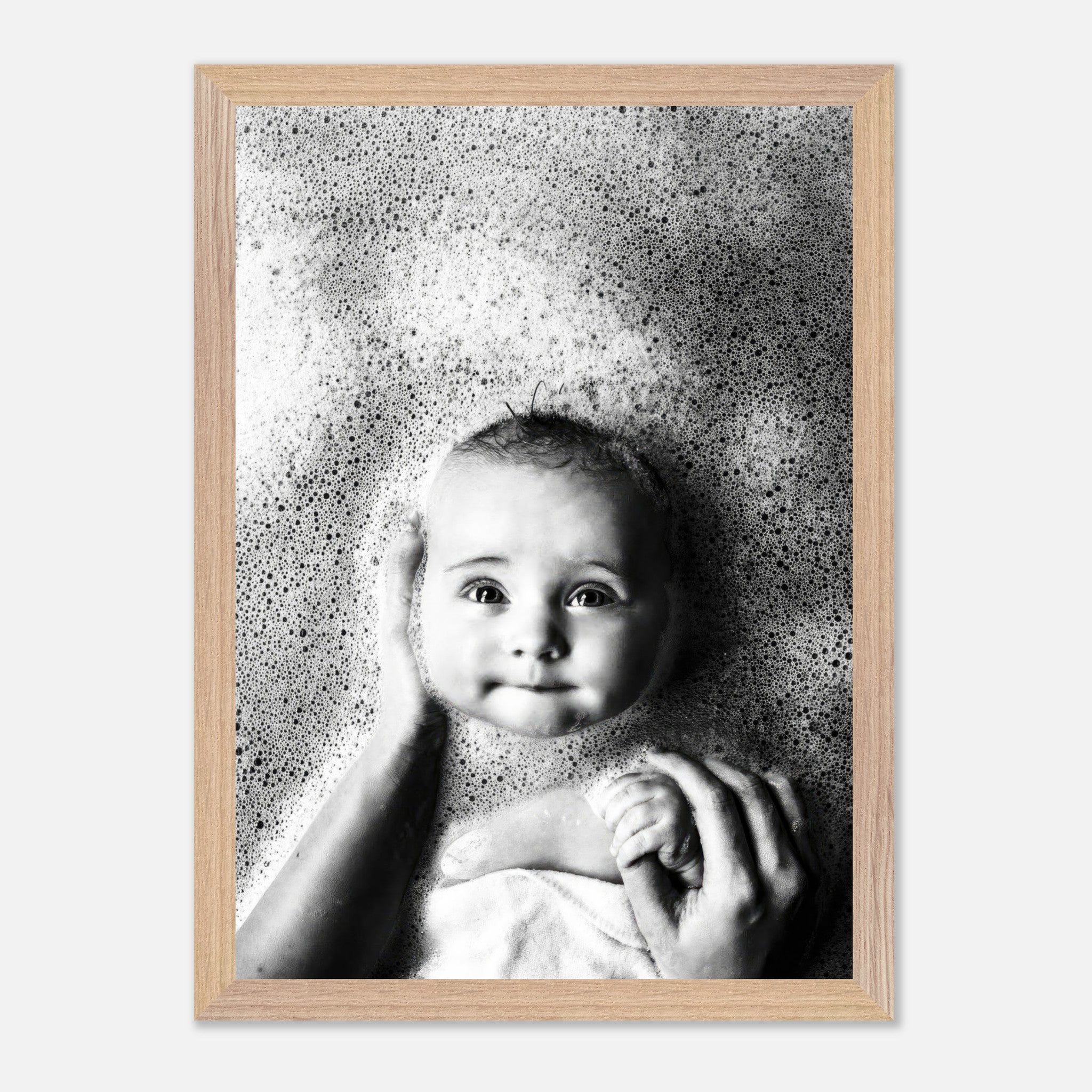 Black and white vintage framed print of a serene baby surrounded by bubbles in a bath.