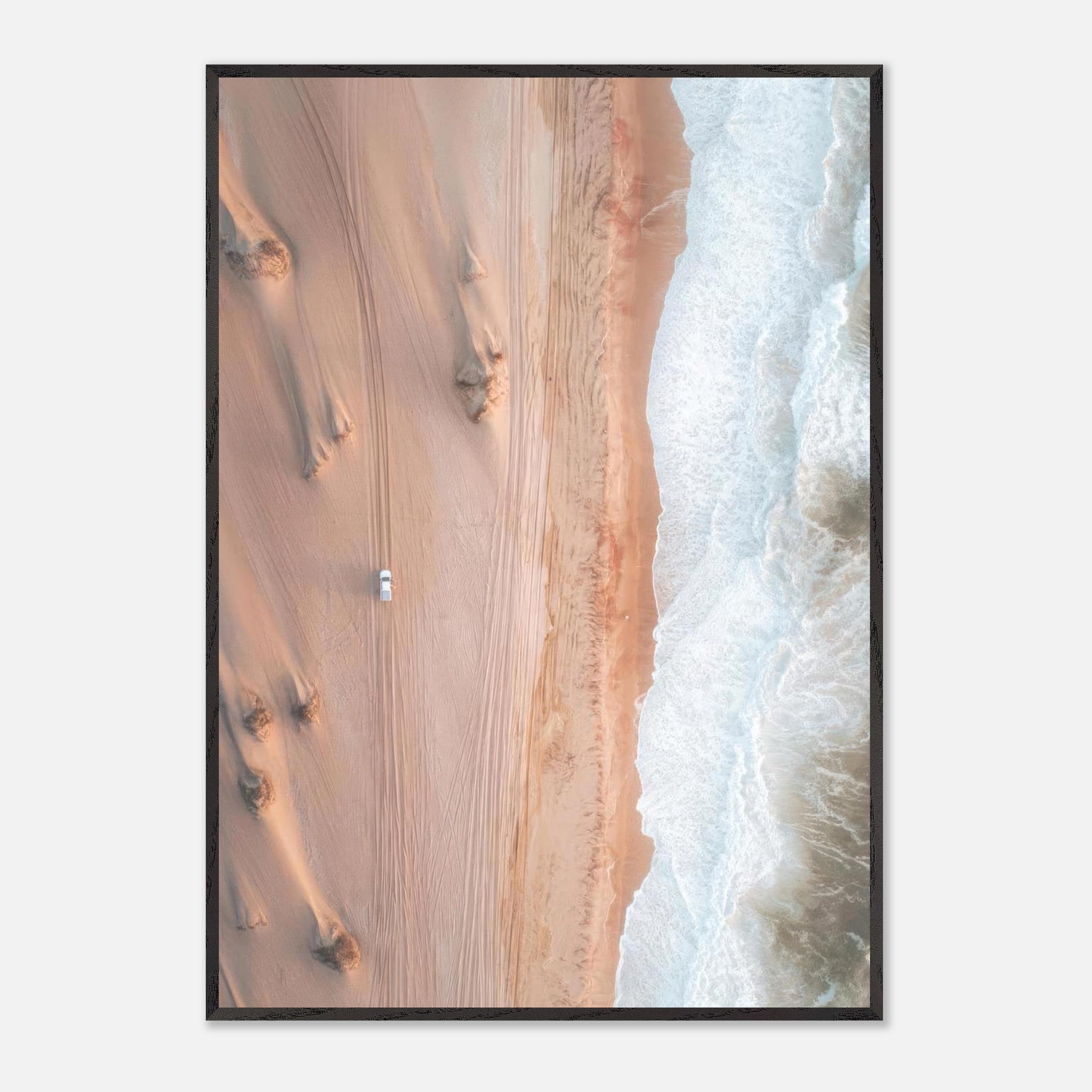 Drone photograph of golden dunes meeting ocean waves, showcasing breathtaking desert and sea contrast.