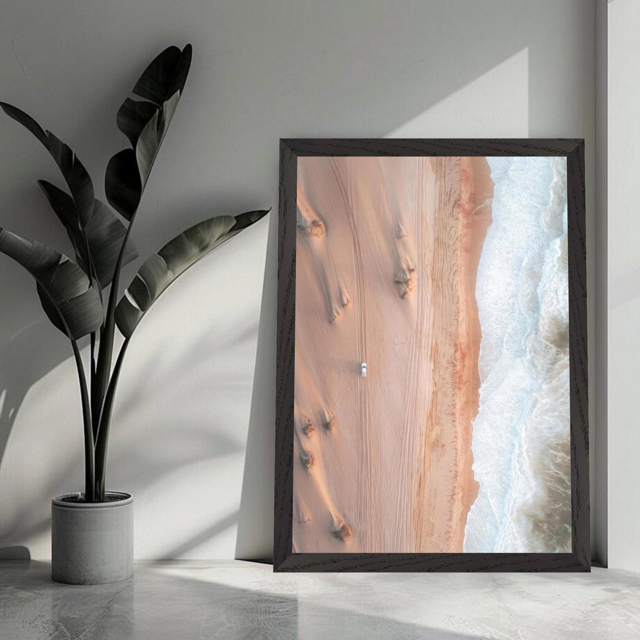 Aerial view of sandy desert dunes meeting ocean waves, framed print showcasing nature's beauty.