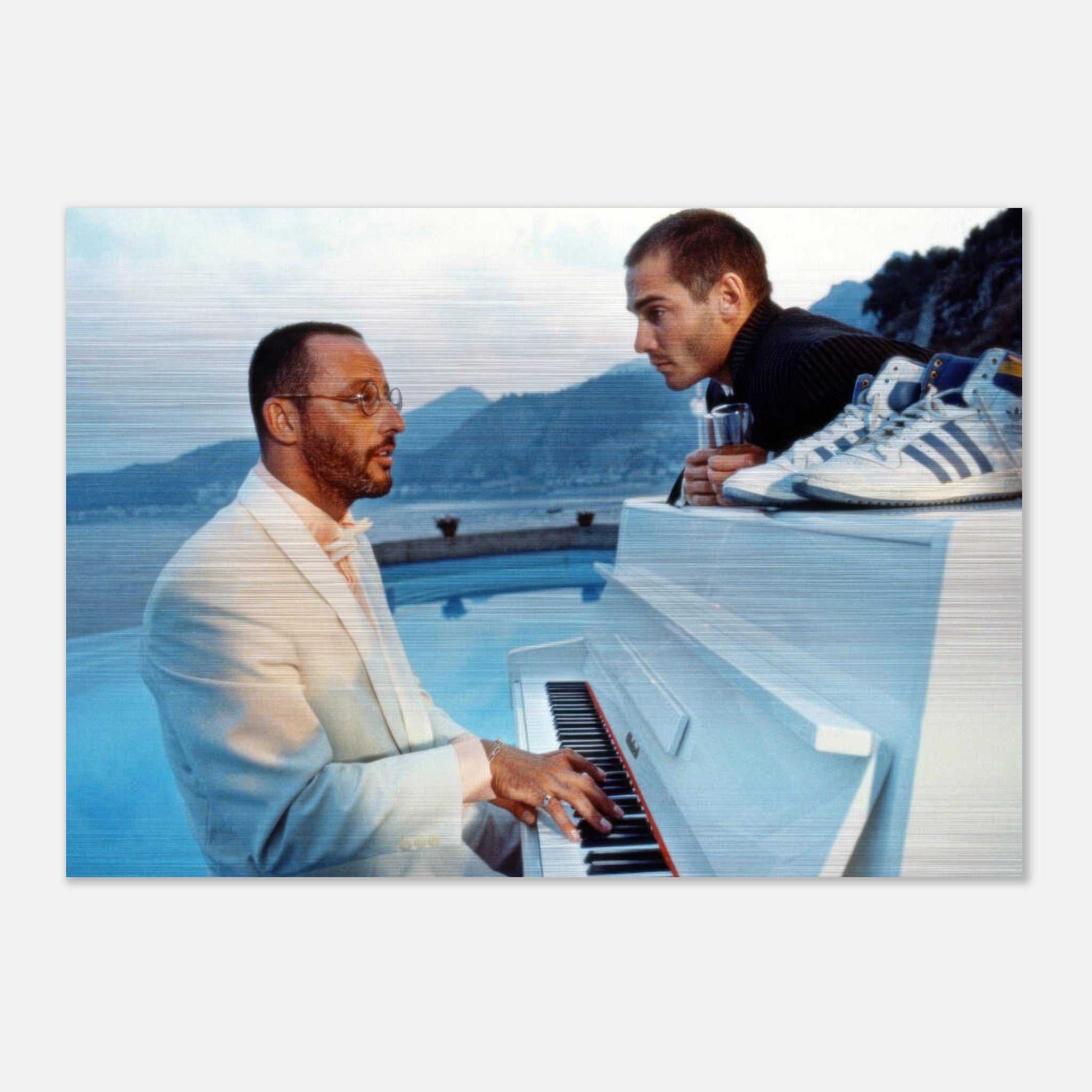 Jean Reno playing piano by the pool, with a friend admiring, set against a scenic landscape. Elegant and stylish moment captured.