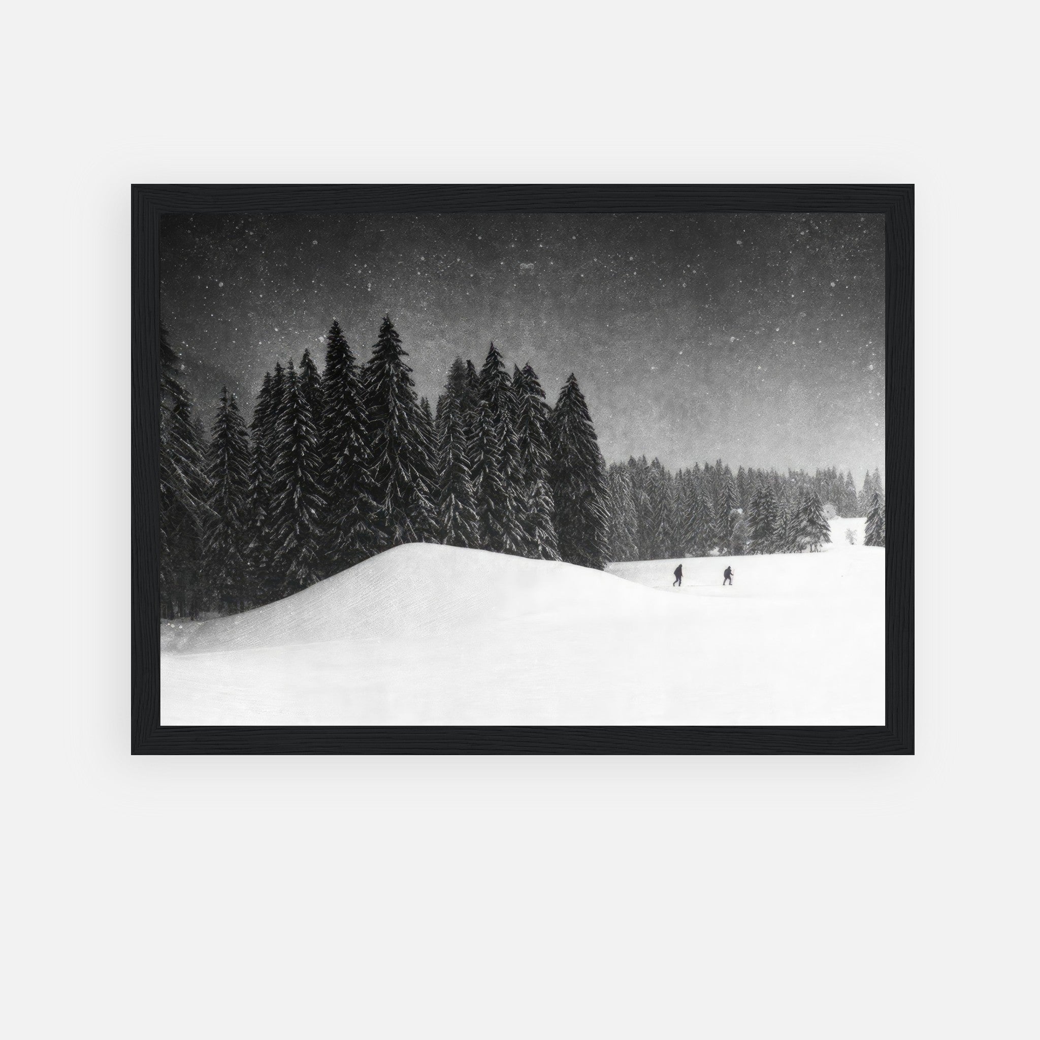 Black-and-white framed print of a snow-covered forest with skiers in a serene winter landscape.