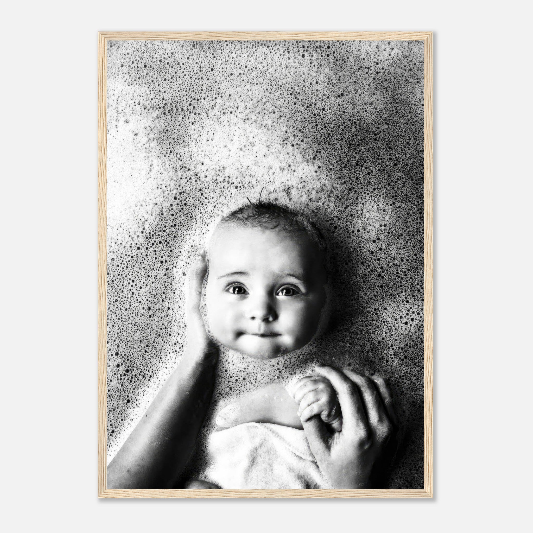 Black-and-white framed print of a baby smiling in a bubble bath, capturing pure joy and innocence.