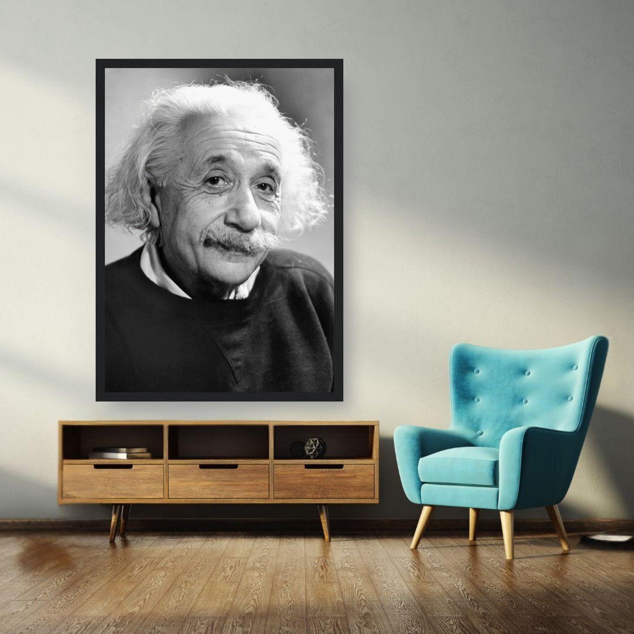 Framed black-and-white portrait of Albert Einstein in a modern living space with a blue chair.