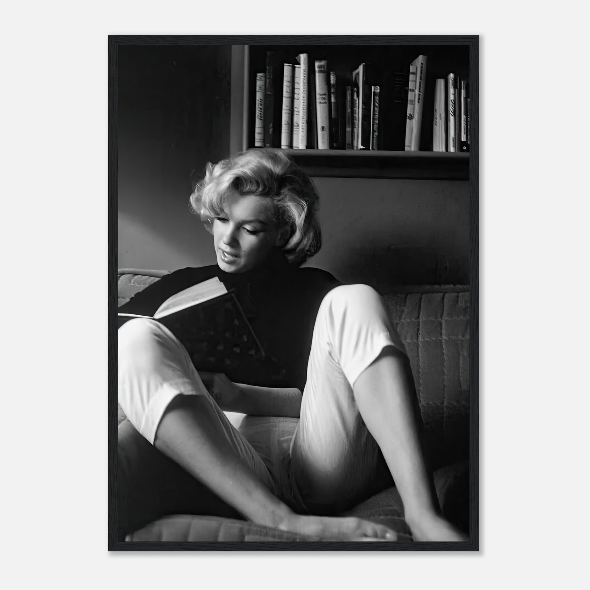 Marilyn Monroe reading intently at home, framed print showcasing classic Hollywood elegance.