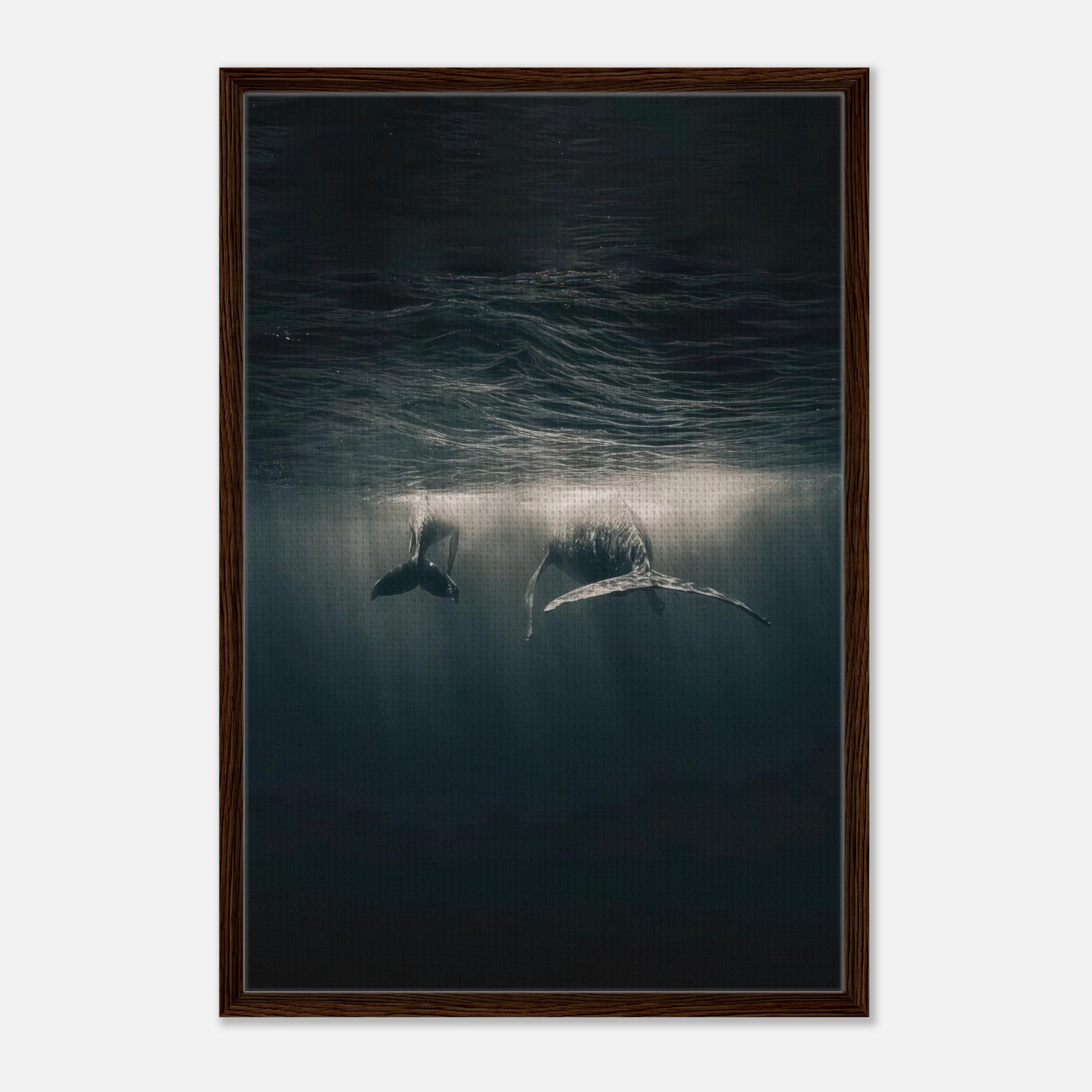 Whales gliding underwater in a framed canvas print, showcasing ocean beauty and light beams filtering through water.