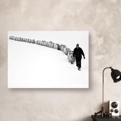 Black-and-white poster of a shepherd walking with a flock in a serene, snow-covered landscape.