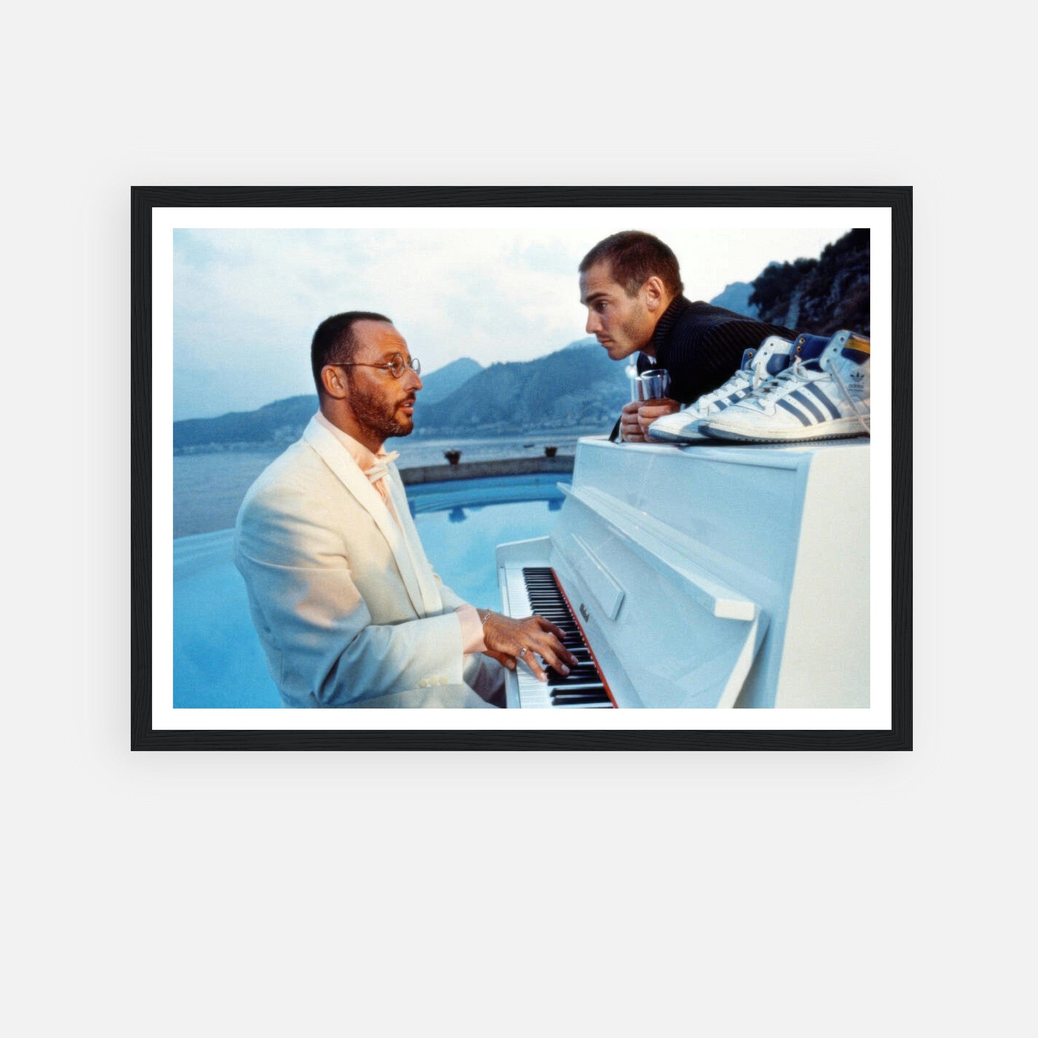 Jean Reno playing piano by the ocean, framed print from "The Big Blue," capturing cinematic nostalgia and serene beauty.