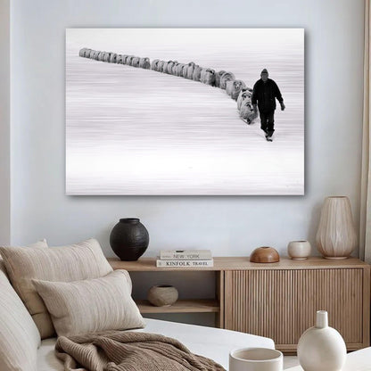 A shepherd walking with a flock of sheep in a snow-covered landscape, captured in black-and-white artwork.