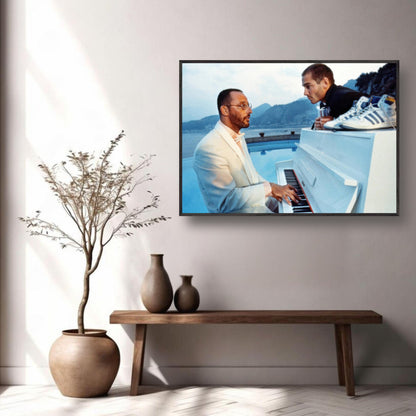 Jean Reno and a friend at a poolside piano, capturing a cinematic moment from *The Big Blue*, in a stylish interior setting.