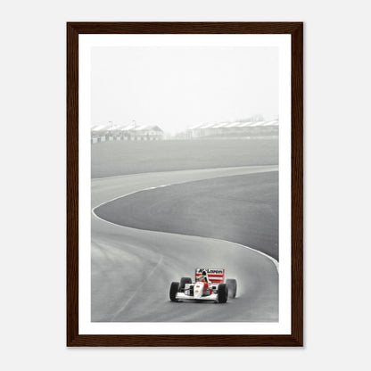 Framed print of Ayrton Senna in the 1988 McLaren MP4/4 racing around a track in black and white photography.