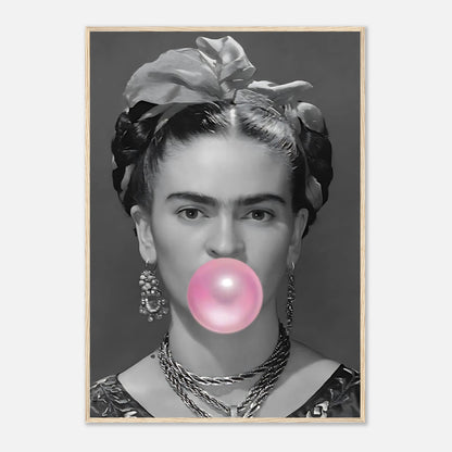 Frida Kahlo framed print featuring a black and white image of her blowing pink bubble gum.