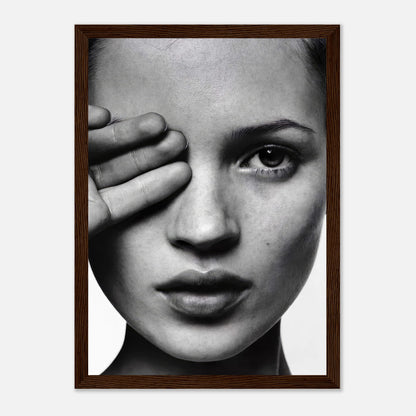 Framed black and white portrait of a model covering one eye, showcasing elegant monochromatic artistry.