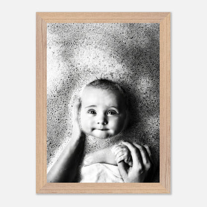 Black and white vintage photograph of a baby in a bubble bath, capturing childhood innocence and nostalgia.