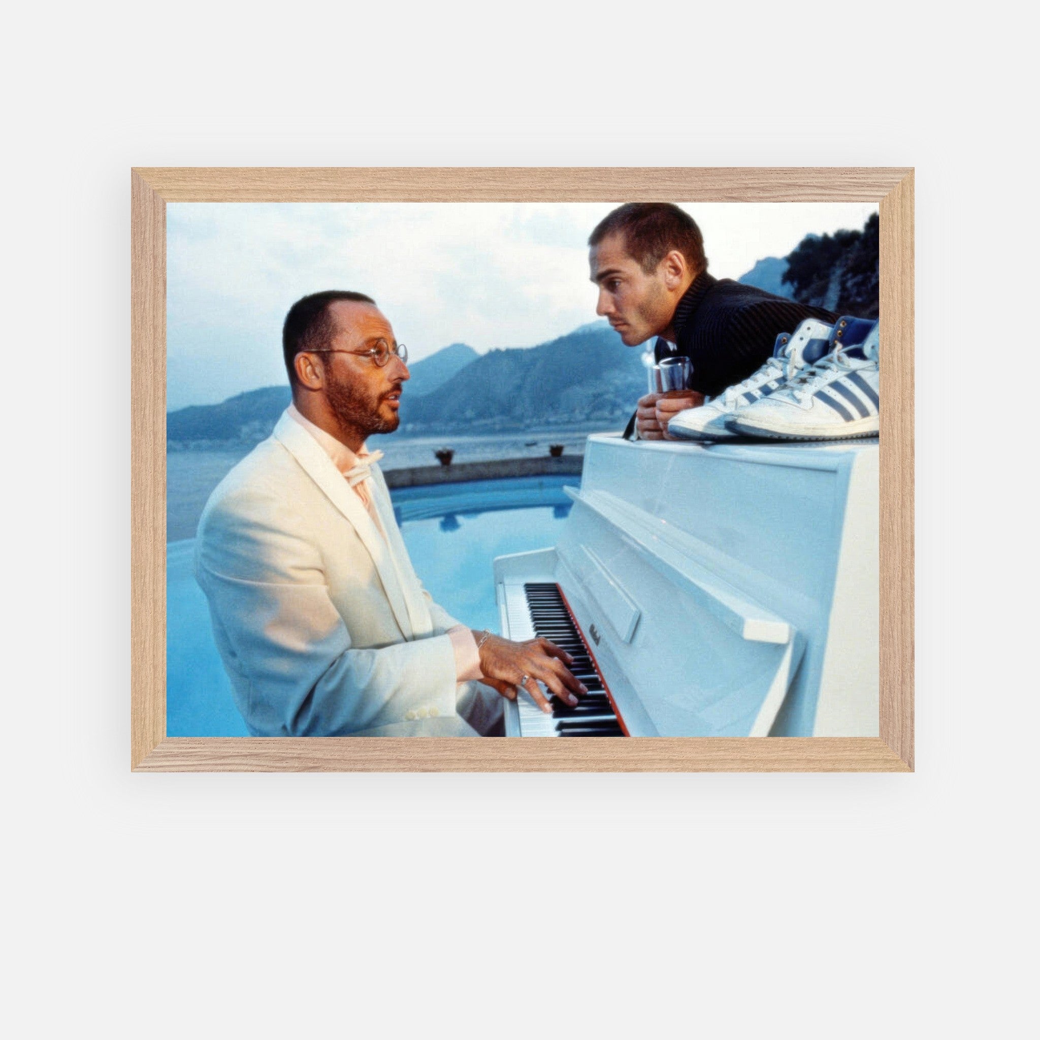 Jean Reno playing piano with a companion in a scenic setting from "The Big Blue," vintage framed print for cinema lovers.