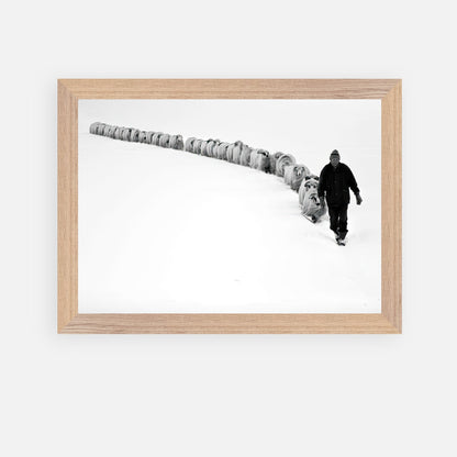 Vintage framed art of a shepherd guiding sheep through a snowy landscape in black and white.