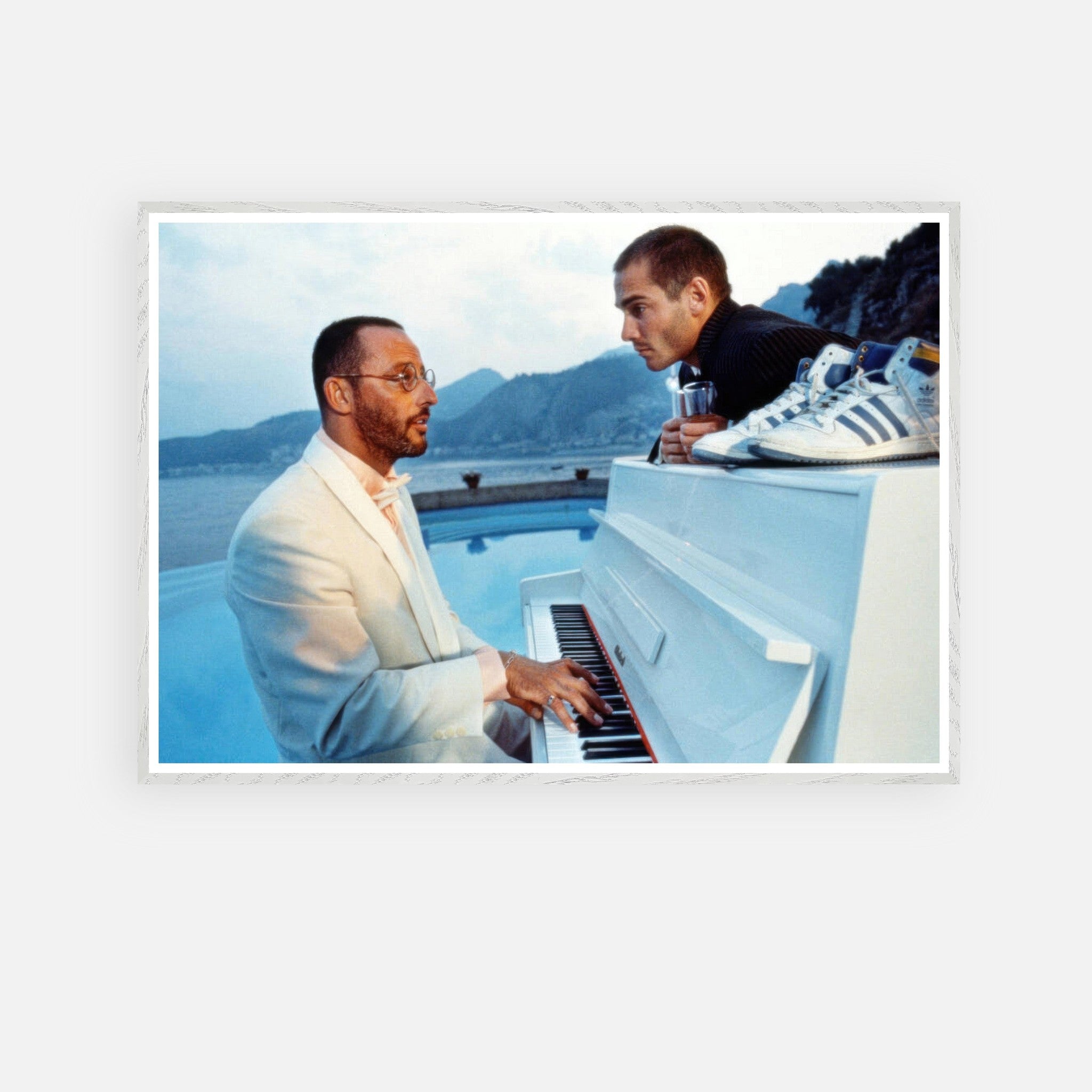 Jean Reno performing piano by the poolside against a coastal backdrop, inspired by *The Big Blue* cinematic moment.