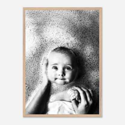 Vintage framed print of a smiling baby in bubbles, capturing the innocence of childhood in black and white.