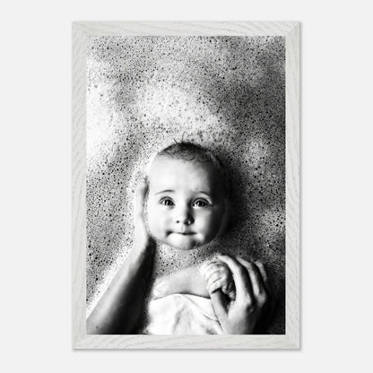 Black-and-white fine art photo of a baby in a bath with soft bubbles, capturing childhood innocence and joy.